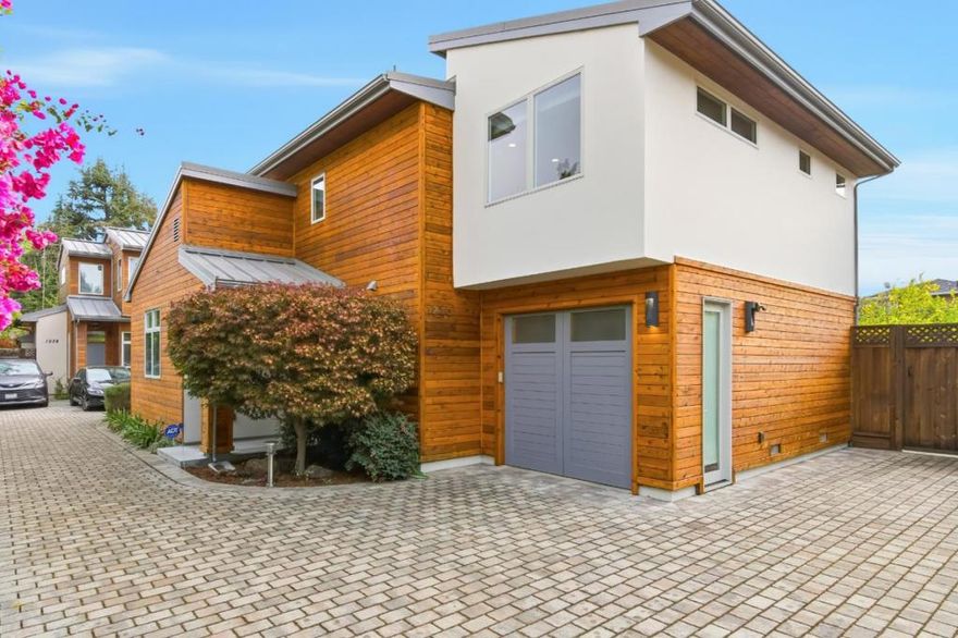 Just a block from downtown, this modern single-family home combines clean design with everyday comfort. The open great room is filled with natural light from multiple windows, vaulted ceilings, and doors that flow directly to the private patio and garden. A gas fireplace with stone surround anchors the space. The kitchen features maple cabinetry, granite counters, island seating, and premium stainless appliances, including Thermador range and built-in wine storage. A main-level bedroom and full bath offer flexibility for guests or office use. Upstairs, two additional bedrooms each have vaulted ceilings and en-suite baths. The primary suite includes a spacious walk-in closet with custom storage and a spa-like bath with dual vanities. Outdoors, enjoy a stone patio framed by citrus and flowering trees. Additional highlights include central A/C, attached 1-car garage, and access to top-rated Menlo Park schools.