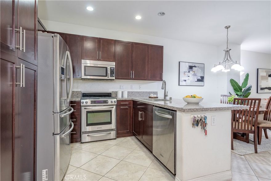 Step into this beautifully designed 3-bedroom home plus a DEN and 3.5 bathrooms, which showcases the largest floor plan in the community at an impressive 1,725 square feet. The first level welcomes you with a versatile den, perfect for a home office or cozy reading nook, along with a thoughtfully positioned half bathroom. Ascending to the second level, you will love the sleek, contemporary kitchen that boasts stainless steel appliances, elegant granite countertops, and a practical serve-over bar that offers casual dining and lively entertaining. Adjacent to the kitchen, an inviting eat-in area provides the perfect space for morning coffee or family meals. The living room serves as the heart of this home, effortlessly connecting to a tranquil outdoor patio—a private sanctuary ideal for relaxation after a long day or for hosting delightful summer barbecues with friends and family. On this level, you'll also find another well-appointed bedroom and a stylish walk-in shower, enhancing the home's comfort and convenience. The third level reveals a dedicated laundry room, two full bathrooms, and a secondary bedroom, alongside the primary suite. This secluded retreat features an en suite bathroom and a spacious walk-in closet, providing both luxury and practicality. Completing this remarkable property is a spacious 2-car side-by-side garage, ensuring ample parking for you and your guests. Nestled within the charming Lotus Walk Community, residents are treated to a lifestyle enriched by desirable amenities, including water utilities, a sparkling community pool, a soothing spa for unwinding, and a welcoming BBQ area ideal for gatherings with friends and neighbors. Conveniently located just a short stroll from the picturesque Haster Basin Recreational Park and the exhilarating Great Wolf Lodge Water Park, this home is a true entertainer's paradise, with the magic of Disneyland only 2 miles away. Easy access to major freeways, including the I-5 and I-22, enhances daily commuting for ultimate convenience. With a vibrant array of restaurants and shops lining Main Street, everything you need is right at your doorstep. Indulge in the perfect blend of comfort, style, and convenience in this remarkable home. HOA includes water, garbage, sewer, outside landscaping, and the common area.