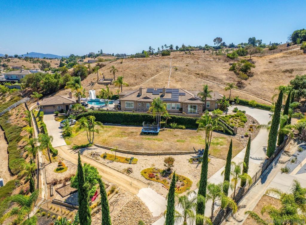 Beautiful Single-Story Estate Located on a Sprawling 1.94 Acre Lot in Peaceful Highland Oaks! Sitting high above the street and at the end of a long private driveway, this stunning home features a total of 4 bedrooms and 4.5 baths between the main home and the guest house. The main house offers an open and inviting floor plan with courtyard entry and high ceilings throughout. All living spaces feature shaved hardwood flooring. Formal living and dining areas. Family room with fireplace and fantastic panoramic views. Wet bar. Chef's kitchen with high-end built-in appliances, granite countertops, dine-in bar, and breakfast area. Master bedroom retreat with fireplace, dual walk-in closets, dual vanities, sitting area, soaking tub with view, and standing shower. Resort-style backyard features a sparkling pool/spa with slide and built-in BBQ - Perfect for entertaining! Panoramic views enhance the outdoor experience. Spacious laundry room with abundant storage. 2 car garage with storage and plenty of additional driveway parking (RV accessible). Central AC + heat. Tesla solar system. Guest house features full kitchen, dining area, living room, 1 bed / 1 bath, and private garage. Hillside is prepped with irrigation and ready for grapes! A breathtaking estate and unique opportunity that is not to be missed!