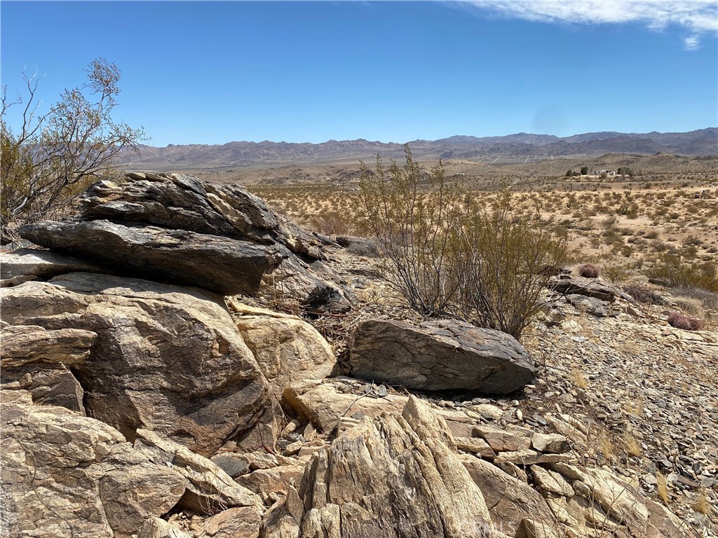 Large 5 Acre Parcel With Scenic Views and Natural Boulders! We invite you to be captivated by this one-of-a-kind 5-acre landscape in Joshua Tree, featuring its own legal address at 3025 Flamingo Ave., which helps streamline the development process. One of the main reasons people flock to our beautiful desert is its unique and breathtaking scenery.
As you drive to this majestic property, you’ll feel a sense of relief, surrounded by vast panoramic views and bright blue skies. This parcel not only boasts one of the most epic backdrops the high desert has to offer, but it also features beautiful natural boulder rock formations, making it a true Joshua Tree masterpiece.
Located just minutes from the charming Joshua Tree village—filled with boutique shopping and gourmet dining—and a short drive from the breathtaking Joshua Tree National Park, this location provides the solitude you seek while keeping you close to the area's major attractions.
Walking the property is not just a viewing experience; it's an immersion in the landscape. Whether you’re looking to build a second home, an investment property, or a primary residence, this is a truly unique opportunity to own your own stunning piece of the desert. This property is the one you’ve been waiting for! Call today to arrange a showing before it’s gone!