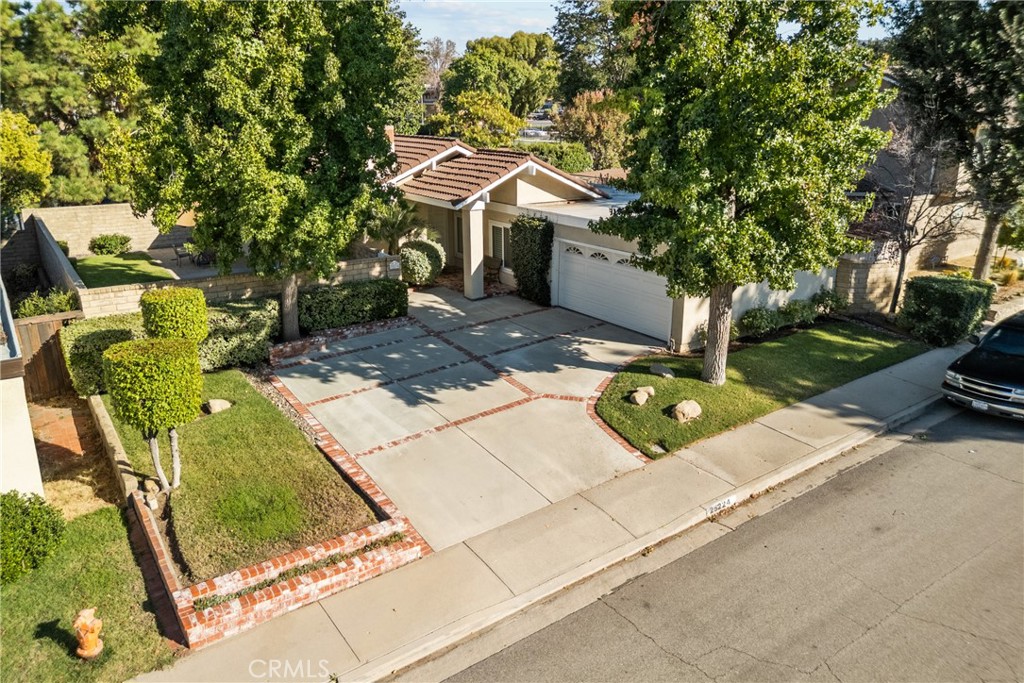 Located on a tree-lined street in the highly desirable Old Orchard 2 neighborhood of Valencia, this beautifully updated single-story home offers a prime cul-de-sac location. Featuring 3 bedrooms, 2 bathrooms, and over 1,400 square feet of living space, the home includes a direct-access 2-car garage and an indoor laundry room. Inside, the family room showcases a custom stone fireplace, complemented by new deluxe laminate plank flooring, Milgard dual-pane windows and sliders, plantation shutters, upgraded baseboards, crown molding, and fresh interior paint. Additional upgrades include LED recessed lighting, ceiling fans in all bedrooms and dining area, mirrored closet doors, and travertine floors in the entryway. Both bathrooms and the laundry room feature new tile flooring, while the kitchen boasts travertine floors, granite counters, beautifully stained birch cabinetry, stainless steel appliances, recessed lighting, and upgraded plumbing fixtures. Recent system updates include new AC ducting, attic insulation, and an exhaust fan, along with new electrical outlets and light switches throughout. The low HOA offers an olympic sized pool and spa, clubhouse, park, access to scenic paseos and walkways, while the location provides close proximity to award-winning schools, great restaurants, entertainment, hiking trails, and easy freeway access. NO Mello Roos!! Offered at $799,999, this heavily upgraded Valencia gem won’t last!