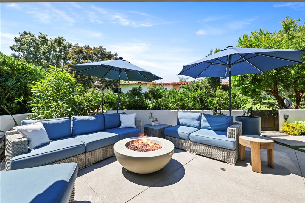 Bathed in natural light and surrounded by greenery, this CORNER home in The Bluffs offers the rare combination of privacy, style, and a true indoor-outdoor lifestyle. Step inside and you’re greeted by soaring ceilings and an open layout that flows easily from the kitchen to the living and dining spaces—perfect for gathering with family and friends or simply enjoying a quiet evening by the fire. The chef’s kitchen is the heart of the home, with a coastal-blue island, quartzite counters, Thermador appliances, and Gaggenau dual ovens for precision cooking. Sliding doors open to an expanded wraparound patio that lives like a second living room, complete with lounge areas, a flat screen TV, fire pit, and tranquil south-facing views of the greenbelt. It’s a space made for morning coffee, al fresco dinners, and evenings that linger long after the sun sets. The primary suite is a calming retreat with dual sinks and convenient attic storage, while two additional bedrooms provide comfort for family or guests. Thoughtful details like ceiling fans in every room, a Dutch door entry, whole-house Halo water filtration, newer A/C, Google Nest, and EV charger in the garage add comfort and ease. Life in The Bluffs means resort-style amenities—lush greenbelts, sparkling pools, and miles of trails that connect directly to the Back Bay. Just minutes away are Eastbluff Shopping Center, top-rated schools, Fashion Island, Balboa Island, and Newport’s most beautiful beaches. This home is more than a place to live—it’s a coastal retreat where every day feels like a getaway.