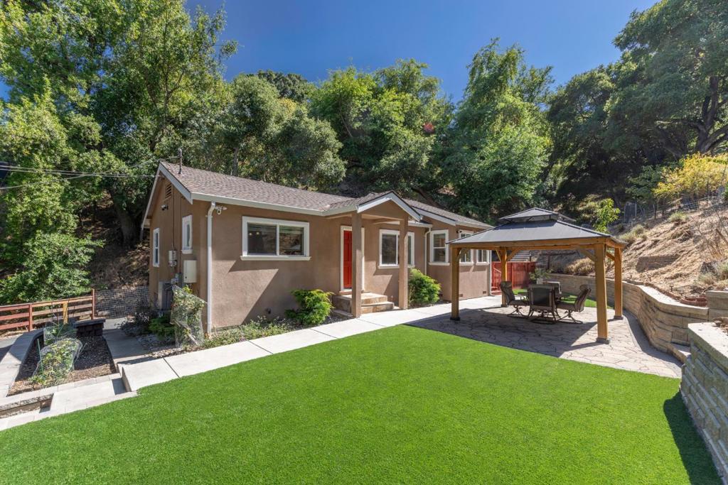 Tucked in a peaceful Cupertino valley, this exceptional estate spanning two parcels offers a rare blend of privacy and natural beauty. A unique opportunity for future flexibility while enjoying a serene lifestyle today. The main home features 2 bedrooms and 2 bathrooms, thoughtfully designed with large windows, custom finishes, and beautiful natural light. The updated kitchen includes granite counters, stainless steel appliances, and ample cabinet space. A vaulted den opens directly to the outdoors, blending indoor and outdoor living. Spacious primary suite features ensuite bath with stall shower and double sinks. Enjoy terraced gardens, a raised patio with turf and gazebo, a fruit orchard, and a private trail that leads to stunning valley views. Despite its completely natural setting, this home is just a short drive to Main Street Cupertino, Vallco Shopping Mall and Apple. Top-rated Cupertino schools, Blue Hills Elementary, Kennedy Middle & Monta Vista High. Quick access to hiking trails, mountain biking, horseback riding and more. Two parcels: one for main house lot 5.85 Acres, the other for vacant land 16,950 SqFt.