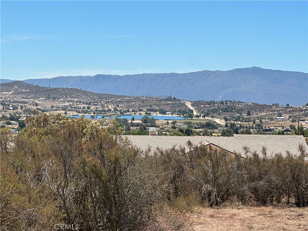This 2.65-acre corner lot in Lake Riverside Estates offers a prime opportunity to build your dream home. Manufactured homes on permanent foundations are allowed, giving you flexibility in your build. The lot is a slightly elevated offering stunning views of the private community lake and surrounding mountain scenery, providing a serene backdrop for your future residence. With its corner location, you’ll enjoy convenient entry from either side of the property. The gently sloping terrain offers multiple potential building sites and room for horses or outbuildings. The lot features a partial graded driveway, nearby power access, and beautiful lake views. The community offers low HOA fees and amenities such as equestrian trails and arena, community pool, playground, picnic areas and a lake for catch and release fishing and recreation and a private airstrip. Just a couple miles away, you’ll find the Cahuilla Casino with market and gas station, adding extra convenience. Located just minutes from Highway 371 and a short drive to Temecula’s wine country or Palm Desert/Palm Springs area, this lot combines peaceful rural living with convenient access to amenities. A perfect blend of country living and accessibility! Come see this property and envision the possibilities—whether it’s a custom estate, a weekend retreat, or an investment in one of Southern California’s most unique communities.