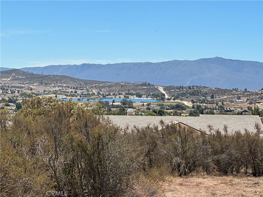 This 2.65-acre corner lot in Lake Riverside Estates offers a prime opportunity to build your dream home. Manufactured homes on permanent foundations are allowed, giving you flexibility in your build.  The lot is a slightly elevated offering stunning views of the private community lake and surrounding mountain scenery, providing a serene backdrop for your future residence. With its corner location, you’ll enjoy convenient entry from either side of the property.  The gently sloping terrain offers multiple potential building sites and room for horses or outbuildings.  The lot features a partial graded driveway, nearby power access, and beautiful lake views. The community offers low HOA fees and amenities such as equestrian trails and arena, community pool, playground, picnic areas and a lake for catch and release fishing and recreation and a private airstrip.  Just a couple miles away, you’ll find the Cahuilla Casino with market and gas station, adding extra convenience.  Located just minutes from Highway 371 and a short drive to Temecula’s wine country or Palm Desert/Palm Springs area, this lot combines peaceful rural living with convenient access to amenities. A perfect blend of country living and accessibility! Come see this property and envision the possibilities—whether it’s a custom estate, a weekend retreat, or an investment in one of Southern California’s most unique communities.