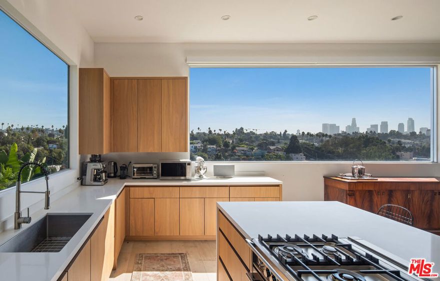 Nestled on a serene residential street near the iconic Silver Lake Reservoir, this beautifully renovated and fully furnished 3-bedroom, 3-bathroom residence offers an elegant blend of light, space, and luxurious design. Upon entering, you'll be drawn to the gourmet kitchen, equipped with top-of-the-line appliances and expansive windows that reveal sweeping panoramic views from the rolling Silver Lake hills to the glittering skyline of downtown Los Angeles. The open-plan layout flows effortlessly, combining spacious communal areas with thoughtful, intimate nooks. Each bedroom is a private sanctuary, complete with a spa-like bathroom, generous closet space and large windows that flood the rooms with natural light. Outside, a private deck provides a tranquil space to enjoy panoramic views across the city, perfect for entertaining. This home offers every modern comfort, including a laundry room, central air conditioning and heating, a private one-car garage, and an additional driveway parking spot. Just a short stroll from local gems, Botanica and LAMILL, this property is the perfect sanctuary for anyone seeking the Silver Lake lifestyle.