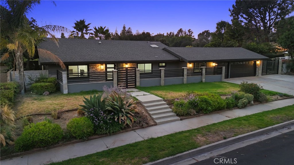 Picture-Perfect Modern Estate in Prime Chatsworth Neighborhood with ADU Potential! Welcome to this sprawling, single-story showpiece located in one of Chatsworth's most sought-after neighborhoods. Designed with a sleek, modern aesthetic, this minimalistic contemporary residence showcases minimalist interior finishes and exceptional craftsmanship throughout. Step into a seamless open floor plan where the living room impresses with a custom TV wall featuring built-in cabinetry, a dramatic slab backdrop, and a sleek electric fireplace. A full wall of windows floods the space with natural light, beautifully complementing the European grey tile floors, and modern finish throughout. The space flows effortlessly into a chef’s dream kitchen outfitted with a massive waterfall island, two-tone matte lacquer cabinetry, quartz countertops, and top-of-the-line Thermador appliances, including a built-in fridge and open shelving. Accordion-style glass pivot doors blur the lines between indoor and outdoor living, opening wide to reveal a resort-style backyard. Set on a massive, usable lot, the outdoor space is your private oasis, complete with modern landscaping, a sparkling pool and spa, sunken fire pit, built-in barbecue center with a Big Green Egg, and HUGE turf and concrete areas. The lot also includes RV access and ample space for an ADU. A dedicated pet-friendly area with privacy fencing ensures your furry friends have their own secure sanctuary. This 4-bedroom, 2.5-bathroom home features a luxurious primary suite reminiscent of a five-star resort. Enjoy serene backyard views through retractable accordion doors, and unwind in the spa-inspired en-suite bathroom adorned with 24”x48” porcelain tiles, black-veined accents, a massive walk-in shower with dual rain showers, and his-and-hers vanities. A spacious walk-in closet completes this dream retreat. Additional highlights include: Designer ocean-blue tiled guest bathroom with floating vanity and tub/shower combo. A private half bath in the fourth bedroom, perfect for guests or office use. Bonus family/media room adjacent to the kitchen, ideal for movie nights. 3-car garage with window views into the home and direct access to the living area. Whether you’re entertaining, relaxing, or envisioning future expansion with an ADU, this home delivers on every level. Don’t miss the opportunity to own this exceptional property in one of the Valley’s most desirable communities!