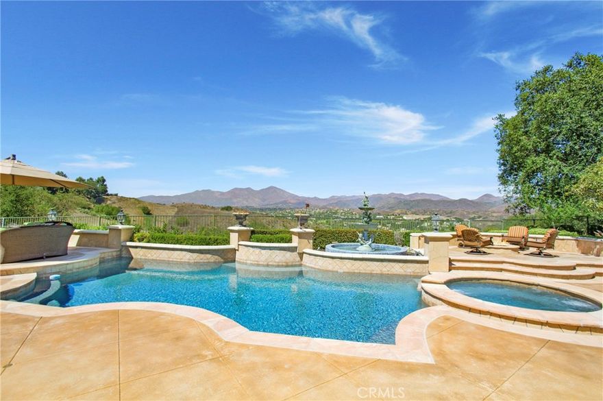 Situated in the guard-gated community of Coto de Caza, this single-level residence exemplifies exceptional design with ridge-top views. Nestled on nearly an acre of land, with a panoramic view of Saddleback Mountain, Cleveland National Forest & the Coto de Caza Valley. The well-designed floor plan boasts 13-ft ceilings, travertine flooring & custom woodwork that creates a sense of luxury. The LR & DR provides a sense of grandeur with a cast stone floor-to-ceiling fireplace and French doors overlooking the pool and expansive backyard. A stunning walk-in wine room built by Vista Wine Cellars centers the home. Enter through Hubbard custom iron doors to Venetian plaster walls, handmade floor tiles, and accented with Idaho Quartz stone. The temperature-controlled room with a separate wine refrigerator for white wine, detailed cabinetry, and seating is one of a kind. The chef's kitchen is a culinary masterpiece, boasting a Sub-Zero refrigerator, Viking 6-burner range with griddle and an abundance of cabinetry. The kitchen nook with backyard view and countertop seating joins the FR with Idaho Quartz stacked stone fireplace, wet bar, and impressive sound system. The finely appointed Primary suite with and backyard access is sure to impress. The Primary Bath w/ skylights for all day natural light, dual vanities, jetted tub, and large walk-in shower, dual commode areas are connected to a walk-in closet. Two large secondary bedrooms and a Jack and Jill bath complete this wing of the home. An additional large bedroom (currently being used as an office) with a private bath and backyard access offers versatility as an in-law suite or bonus area. The breathtaking backyard oasis takes full advantage of the mountain and valley view. The Pebble tech pool & spa centralizes the generous patios. Stone accented BBQ cooking area with the most impressive backdrop, dazzling all your guests! An elevated fire pit is perfect for those nighttime gatherings. Large California oak trees, a grass area & a vegetable garden complete the backyard. 4 garage with epoxy flooring (2-car garage being used as a wood workshop). This residence epitomizes the finest of Coto living, offering access to biking & hiking trails, parks, & sports courts. Residents also have the option to enjoy the amenities of the Coto de Caza Golf & Racquet Club for an additional fee, which features two Robert Trent Jones Jr.-designed golf courses, tennis courts, pickleball courts, a spa, a gym, pro shops, and restaurants.