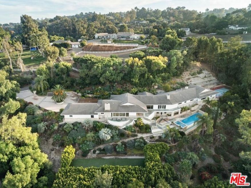 Fixer alert! Within the gates of Rolling Hills, where privacy and scale are guarded by design, an unfinished two-story ranch sits on 2.63 acres of west-facing land, suspended between concept and completion. The structure spans 11,686 square feet, with seven bedrooms and eight baths, and is mid-remodel. More than a million dollars in high-end finishes, fixtures, cabinetry, and appliances are already on-site, boxed, labeled, and ready. Architectural plans are complete, HOA approvals secured, and the current vision includes a home theater, gym, expansive primary suite with spa bath and boutique closet, infinity lap pool, spa, pickleball court, croquet lawn, and meandering garden pathsset against unobstructed views of the Pacific Ocean, the Queen's Necklace, and the downtown Los Angeles skyline. Yet nothing is final. Developers can complete the project, or pivot toward a new plan entirely. Owner-users seeking to build to suit can bring their own aesthetic and ambition. A circular motor court offers scale and presence, while equestrian zoning adds uncommon flexibility. The Rolling Hills community, with its rural atmosphere and enduring appeal, promises seclusion, security, and long-term value. Located in the top-rated Palos Verdes Peninsula Unified School District and minutes from beaches, freeways, and luxury amenities, this is a rare opportunity to create something exceptional in one of Southern California's most storied enclaves.