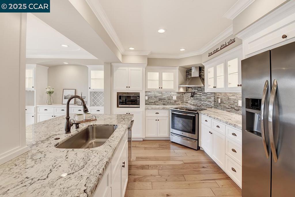 Elegant Custom Remodel in Rossmoor 55+ Community. Step into sophistication with this beautifully remodeled CO-OP, showcasing designer finishes throughout. Enjoy cove ceilings, recessed lighting, stone countertops, and stainless steel appliances. The kitchen features extended counters into the dining area, under-cabinet lighting, and windowed upper cabinets. A stunning electric fireplace, custom wood and tile flooring, and a versatile enclosed space perfect for an office or hobby room add to the appeal. Large stall shower in primary and walk in jetted bathtub/shower in 2nd bathroom. Located in the vibrant, gated Rossmoor 55+ community, this home offers more than just comfort—it offers a lifestyle. Indulge in golf, tennis, pickleball, bocce ball, hiking, fitness center, movie theater, dog park, hobby rooms, and 200+ clubs.