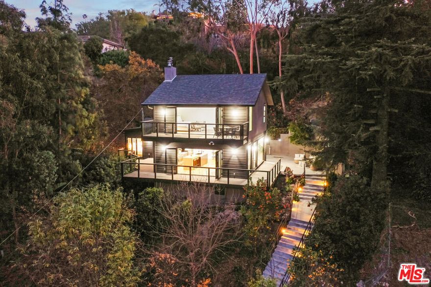 Nestled high above the road, amidst an emerald forest of mature trees, you'll discover a truly exceptional retreataffectionately known as The Round Valley Tree House. This residence has been meticulously reimagined, taken down to its framing and thoughtfully modernized with the utmost attention to detail.Boasting a soaring Modern-Farmhouse design, this home offers unobstructed panoramic views, thanks to an open-concept layout and a striking floor-to-ceiling retractable glass wall. Expansive viewing decks, wide-plank oak floors, warm recessed lighting, and sophisticated architectural features elevate the space, while the gourmet eat-in kitchen is equipped with top-tier appointments, including imported French cabinetry and premium Fisher & Paykel appliances.The upper level features a loft-style master suite, where you'll wake up to breathtaking jetliner views of the valley, mountains, and city lights below. Four uniquely designed and elegantly appointed bathrooms add to the home's refined character.The inviting outdoor spaces are equally impressive, with lush, up-lit landscaping, wraparound balconies, an alfresco dining patio, terraced gardens, and even a pair of nostalgic hammock swingseach thoughtfully positioned to capture the stunning vistas in nearly every direction.The Round Valley Tree House offers an unparalleled level of quality, sophistication, and tranquilityan exceptional lifestyle, elevated in every sense.