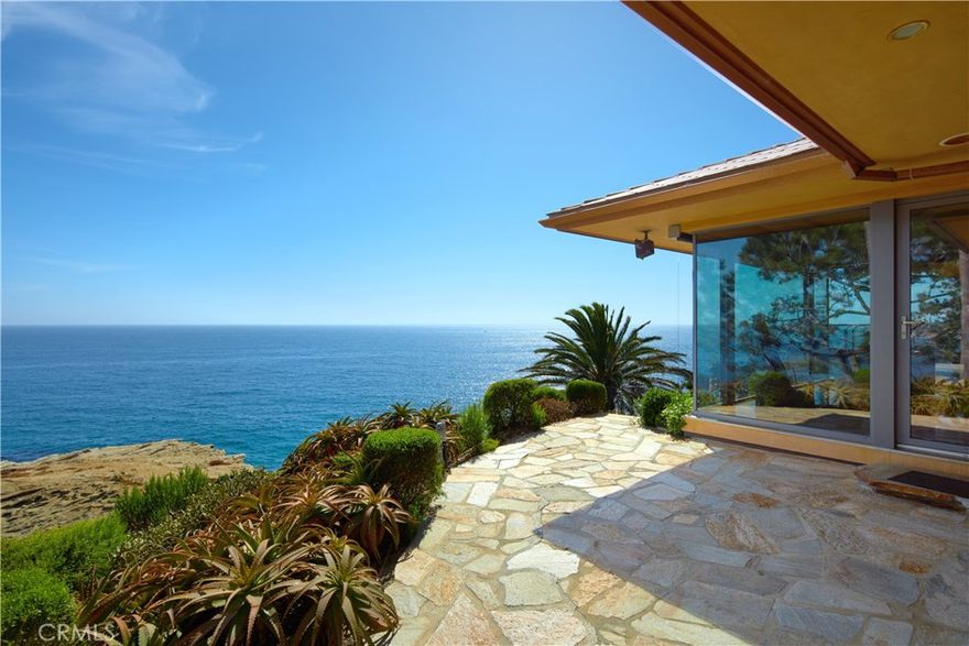 Rarely does a property of this magnitude present itself on the market. A custom ocean-view estate where artistry and nature unite on a blufftop promontory towering over the ocean. A welcoming home that is part luxury, part beauty, and 100% Laguna Beach. Enjoy views that encompass Dana Point, Catalina Island, colorful sunsets, breaking waves, and twinkling evening lights are viewed from most indoor and outdoor living areas at the estate. Located at the end of a private cul-de-sac in South Laguna’s gated Three Arch Bay, the appx. 2.15-acre property encompasses the bluff and part of the beach below. Custom hand-carved mahogany garage doors and a matching entry gate enrich curb appeal, and a private courtyard with Inca Gold natural stone welcomes all with a pool with water feature, electric cover and massaging jets; a built-in  Twin Eagles BBQ bar and Salamangrill and retractable Sunbrella awning; two fire pits and outdoor shower; a full outdoor bath; Bromic heater; and bespoke art from Laguna’s renowned Marlo Bartels. Floor-to-ceiling windows, glass doors, and sliders from Germany’s NanaWall unite exterior spaces with a fabulous interior, where immediate ocean views are experienced upon entry. Main living areas comprise a custom walk-in wet bar with ice-effect glasswork, handmade African movingui cabinetry, a see-through fireplace, a grand dining room that opens to the pool, and a family room with access to an outdoor view deck. The kitchen is as beautiful as it is functional thanks to an island with Brazilian granite top, custom aluminum-finished cabinetry crafted by Bulthaup in Germany, two built-in Miele refrigerators, and a suite of Gaggenau appliances. Blue Bahia and Blue Pearl Granite shine in the primary suite, and select secondary baths reveal Keuco vanities and mirrors. The lower-level theater is accessed by a Garaventa lift and features state-of-the-art A/V equipment. A garage with lift accommodates four cars, a driveway that can fit up three cars, and a Kohler gas backup generator, Lutron lighting, Elan audio, an aluminum roof by Future Roof Systems of Canada, fast water-heating systems, and a 500-gallon whole-home reverse-osmosis system are included.