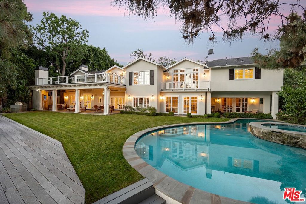 Holmby Hills Gem, Traditional Estate - redesigned and furnished by Steve and Brooke Giannetti. Set behind high gates on just under 1/2 acre of manicured grounds. Soaring 2-story entry hall, with floating staircase. Formal living room with fireplace, wood paneled media room with incredible bar area. All public rooms open via French doors to grassy yard and pool. Gourmet kitchen with adjacent family room. Exquisite primary suite with high ceilings, double marble baths with incredible moldings and large walk-in closets. 5 additional bedrooms. Large 3 car garage. A tree top view - rare for Holmby Hills. Must see! Shown only to prequalified buyers.