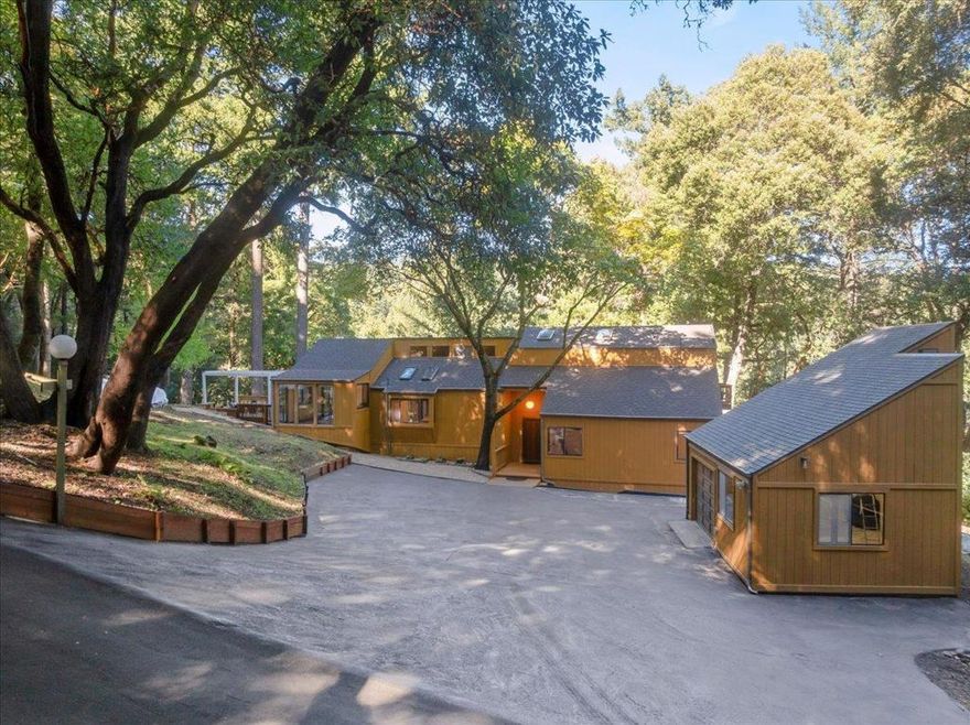 Escape to tranquility in this stunning home nestled in the forest of the sought-after Las Cumbres community. Dappled in natural light through soaring skylights and surrounded by nature, this unique home offers a seamless blend of rustic charm and modern comfort. Step inside to discover vaulted ceilings, and an open-concept layout with multiple lofts, designed for relaxation and entertaining. The kitchen features a bay window breakfast bar, perfect for morning coffee, and flows effortlessly into the dining room and dramatic wraparound glass entertaining nook invites the outdoors in, showcasing spectacular cross-canyon views. Enjoy the ultimate in outdoor living with numerous decks, ideal for gatherings, stargazing, or soaking in the hot tub under the forest canopy. A detached garage with loft and workshop provides ample space for hobbies or a creative studio. On the grounds, you'll even find an ancient Indian grinding stone, connecting this serene setting to the regions rich history where light, space, and serenity come together in perfect harmony. Las Cumbres community residents enjoy a vibrant lifestyle with tennis and basketball courts, a sports field, swimming pool, bocce ball, community BBQ area, and playground. High-speed internet, award-winning Los Gatos High School.