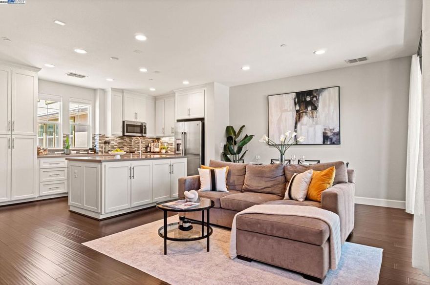 Stunning SAGE Condo with loads of natural lighting throughout. Impeccably maintained by original owner with several upgrades including wood flooring, upgraded cabinets, island, quartz counters, tile backsplash, stainless steel appliances, surround sound, recessed lighting and more!  Enjoy relaxing and grilling on your own glass enclosed private patio. The additional features include dual pane windows throughout, central heating and A/C, tankless water heater, and 1 car garage with added storage nook.  Don't miss the well thought-out SAGE community amenities including fitness center, pool, hot tubs, luxurious club house, cabanas, grills, parks, flower gardens, community gardens, lawn & yoga area, bocce, and more! Excellent location - minutes from the freeway, BART, nearby shopping, Las Positas College, Costco, wineries and Downtown. Walk to additional parks and tranquil settings of nearby trails.