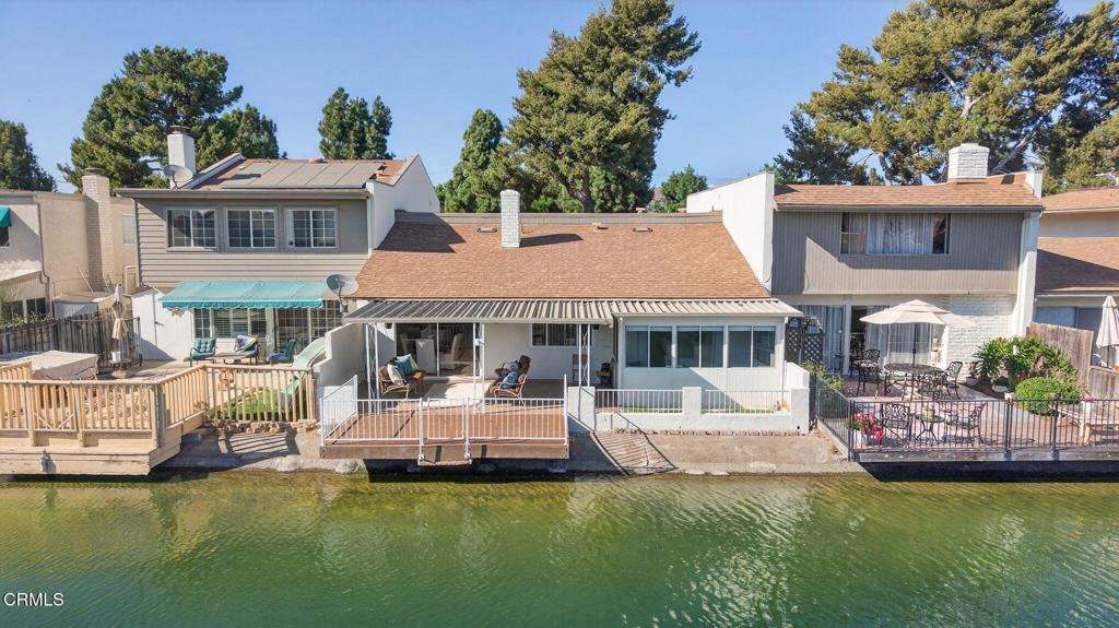 Welcome to lakeside living at 1656 Shoreline - a rare waterfront home in Camarillo's sought-after Lakeside Village. Set directly on the water with a private, gated deck, this residence feels like a page from a design magazine and the kind of peaceful retreat everyone dreams about. Watch friendly ducks glide by, spot turtles sunning on the banks, and enjoy catch-and-release fishing right from your own deck. Launch a kayak, canoe, or paddleboard and explore the meandering lake, then unwind under the large covered patio while the water shimmers around you. You are greeted by a custom sand finished colored concrete driveway that leads to a private rock faced gated courtyard that sets the tone. Inside, the home blends warmth and style with highly curated updates. The finished, enclosed courtyard front room showcases soaring ceilings with exposed beams, skylights that invite in the sunshine, recessed lighting, and wide-plank wood-look flooring for a seamless, coastal feel and adds an additional 400 square feet of space for your enjoyment. The main living space opens through large sliders and leads to the patio - perfect for effortless indoor/outdoor entertaining. The remodeled kitchen is both beautiful and functional, featuring quartz counters, a textured stone backsplash, modern hardware, and sleek appliances - an ideal workspace for everyday meals or weekend gatherings. Two comfortable bedrooms and two updated baths provide easy single-level living. The serene primary suite enjoys sparkling water views and flows into an enclosed, patio/sunroom--offering an additional 100 sq feet of versatile space for a lounge, office, hobby room, or quiet reading nook with the lake as your backdrop.Outdoors, the oversized deck offers multiple zones for dining and lounging, with room for friends, pets, and play. Morning coffee, golden-hour appetizers, and star-filled evenings all feel a little more magical here.With a highly updated 1,214 sq ft of living space, 2 bedrooms, 2 bathrooms, and the unique approximate 500 sq ft of permitted patio rooms, you have the perfect combination to enjoy this true lakeside oasis. Lakeside Village is known for its unique, park-like setting with wandering paths and tranquil water views--yet it's conveniently close to Camarillo's shops, restaurants, and commuter routes. If you've been searching for that hard-to-find combination of style, comfort, and a true waterfront lifestyle, this is the one.
