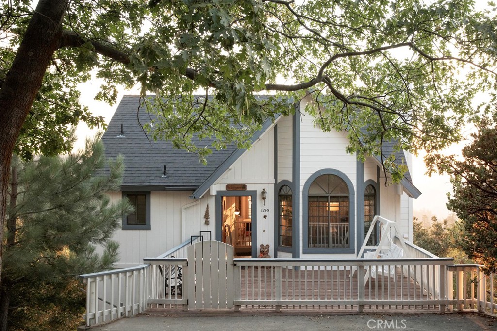 Welcome to Evergreen! Tucked high among the trees with panoramic mountain views, this dreamy cabin feels like a true escape from the city. Thoughtfully designed with contemporary comfort and vintage touches, it’s the kind of place that invites you to slow down and stay awhile. Enjoy easy, level entry into the main floor, where you’ll find the living room, dining room, and kitchen, each space cozy and light-filled, with vaulted ceilings and picture windows that frame the trees and capture the view. A wood burning fireplace in the living room adds warmth, while the large deck is perfect for sipping coffee and taking in the views. The primary bedroom is also on this level, with soft light, simple touches, and direct access to the deck. Downstairs, two guest rooms each have their own feel, one with vintage inspired wallpaper and a moody, layered vibe, the other bright and minimal. Both look out to the trees and offer just the right amount of space to wind down. Minutes from the Village, the golf course, and some of the best hiking in the area, Evergreen is the perfect mix of comfort, nature, and mountain charm. Currently operating as a short term rental, it’s a great opportunity to own a little slice of Lake Arrowhead, with lake rights included.