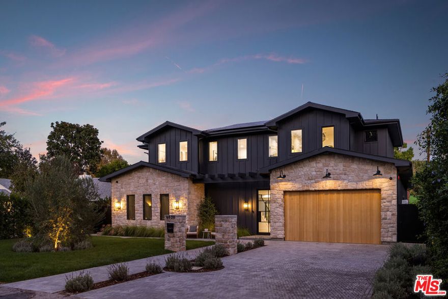 A striking statement in farmhouse luxury, this newly built estate with an attached ADU/guest house rests on a generous lot in the heart of Valley Village. Crafted for both everyday comfort and sophisticated entertaining, the open-concept main living space is centered around a chef's kitchen outfitted with premium Thermador smart appliances and an expansive island with seating. A formal dining area and spacious living room complete the main level, highlighted by an oversized sliding glass door that opens wide for seamless indoor-outdoor living.Step outside to discover a private backyard oasis featuring a sparkling pool and spa, framed by low-maintenance artificial turf that invites relaxation and play. Upstairs, four ensuite bedrooms provide ample retreat, complemented by a dedicated laundry room. The refined primary suite offers a private balcony, custom walk-in closet, and spa-inspired bath with soaking tub, rainfall shower, and dual vanity.The attached ADU, with its own private entrance, presents a versatile living arrangement with a comfortable lounge, kitchenette, two bedrooms, and two bathrooms  ideal for extended family, guests, or a home office. Additional highlights include a multifunctional media room, soaring ceilings, a two-car garage, and a Control4 smart home system with integrated speakers, Nest thermostat, and security cameras.Perfectly positioned within the highly regarded Colfax School District, this property is just moments from the vibrant dining, shopping, and entertainment and Ventura Boulevard.