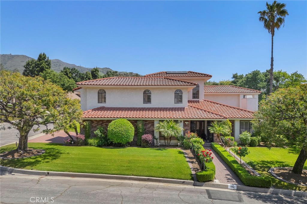 Discover the perfect blend of sophistication and comfort in this exquisite Morgan Ranch residence, nestled against the breathtaking foothills of Glendora. From the inviting brick entry to the luxurious backyard retreat, every inch of this home is designed to impress. Step inside and be welcomed by soaring high ceilings, a grand European Crystal Chandelier, and multiple living spaces, including a formal living room, family room, and elegant dining area. The multi-generational floor plan offers a downstairs bedroom with an adjacent bathroom — ideal for guests or added flexibility. The expansive kitchen is a culinary dream, featuring a Sub Zero refrigerator and freezer, double ovens, a huge island with prep sink, breakfast bar, dual pantries, pots and pans drawers, and abundant cabinet and counter space. The kitchen seamlessly opens to the family room, creating the ultimate gathering space for entertaining. Slide open one of the many glass doors and embrace the famed California indoor/outdoor lifestyle. Dine al fresco under the covered patio or unwind in the private backyard oasis. The spacious primary suite is pure indulgence, offering a private balcony accessed through French doors, a cedar-lined walk-in closet with custom organizers, a Roman-style soaking tub with skylight, walk-in shower, and a dual-sink vanity. Additional luxuries include a central vacuum system, recessed lighting, ceiling fans, two fireplaces, entry skylight, a Murphy bed, built-in work/study space, plantation shutters, and a full upstairs laundry room with utility sink and storage. Climate control is effortless with upper and lower heating and A/C systems, along with two water heaters (one tankless). The resort-style backyard is a personal paradise, featuring a gated pool and spa framed by a one-of-a-kind hand-painted mural, a built-in grill and sink, a cozy fire pit, and lush mature landscaping with vibrant rose bushes and a fruitful orange tree. The oversized three-car garage offers direct access, automatic roll-up doors, and extensive storage solutions. Perfectly situated minutes from Glendora Country Club, award-winning schools, upscale shopping, and diverse dining, this home captures the very essence of Southern California luxury living. Don’t miss the chance to own a true Morgan Ranch masterpiece!