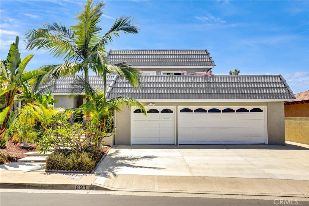 Tucked behind the gates of the prestigious Bixby Hill community lies this luxurious entertainer’s dream home, where timeless elegance meets modern upgrades in one of Long Beach’s most desirable neighborhoods. This luxurious 5-bedroom, 4-bathroom residence offers 3,293 sq ft of refined living space on a beautifully landscaped 10,641 sq ft lot, thoughtfully designed for comfort, entertaining, and multigenerational living. From the moment you step inside, you’ll feel the exceptional blend of elegance and functionality. The split-level floor plan features a main level with a formal living room, formal dining area, and a fully remodeled chef’s kitchen. Outfitted with high-end finishes, the kitchen boasts soft-close drawers and full pull-out cabinetry, topped with exquisite granite counters. The premium LG Studio appliance package includes double ovens, a 5-burner electric cooktop, dishwasher, and stainless-steel refrigerator, perfect for entertaining. Just off the kitchen, you’ll find a beautifully designed BBQ area and a serene sitting space, ideal for outdoor dining or unwinding in the peaceful surroundings. A spacious lower level features a large family room, wet bar, utility room and 2 additional bedrooms ideal for a mother-in-law suite. Upstairs, two additional bedrooms look out over the resurfaced upper private deck, offering tranquil views and a seamless indoor-outdoor connection. Enter through double doors to the oversized primary suite, a luxurious retreat featuring a walk-in closet, private in-suite laundry, and a spa-like bathroom, perfectly designed for relaxation and convenience. Step outside to your private sanctuary backyard, newly landscaped with custom hardscape, a spacious 12-person jacuzzi, built-in custom fire pit, gazebo, private pet-friendly side yard with brand new sod, and string lighting that sets the mood for evenings under the stars. Whether you're hosting a summer gathering or enjoying quiet nights in, this backyard is a true entertainer’s dream. The home features a list of modern upgrades, including a newer roof, newer exterior/interior paint, newer windows, newer hardwood floors, upgraded HVAC system, insulated copper plumbing, solar panels, and resurfaced upper deck. Located directly across from California State University Long Beach and within walking distance to the Carpenter Performing Arts Center, this prime location offers the best of education including SATO Academy, culture of Rancho Los Alamitos, and coastal living.