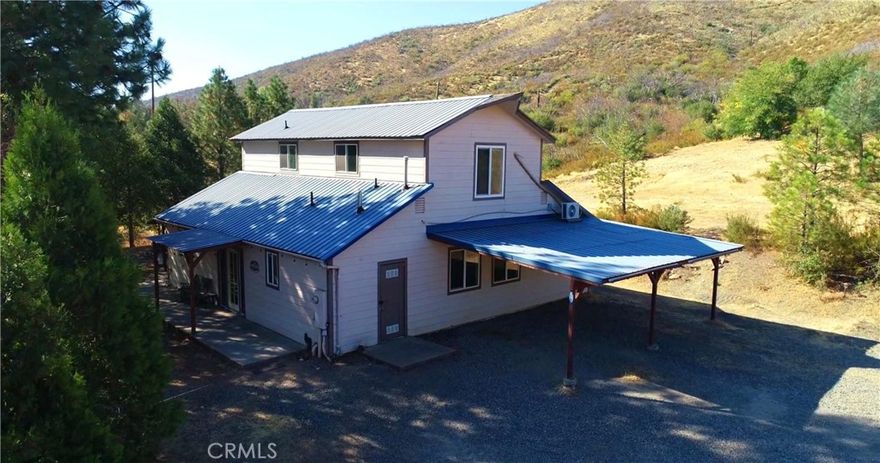 Cute Barndominium Style Home loaded with Curb Appeal! Scenic Views! Excellent Location for Valley Commuters. This Basic Beauty has over 2,000 sq. ft. with 3 bedrooms & 2 full bathrooms. Spacious Open Floor Plan is simple but sweet. 2 master bedrooms; one upstairs & one downstairs. The large, open upstairs room is suitable for gaming or crafting & has lots of built in storage. The shady backyard area features a built in sink with tile counters, & a covered porch with concrete floor, perfect for outdoor entertaining. The upper pad has a 400 sq. ft. garage/ workshop with roll up door & a concrete floor. This developed area also has two 2,500 gallon water storage tanks, privacy from the home & water/ septic hookups for RV or travel trailer.