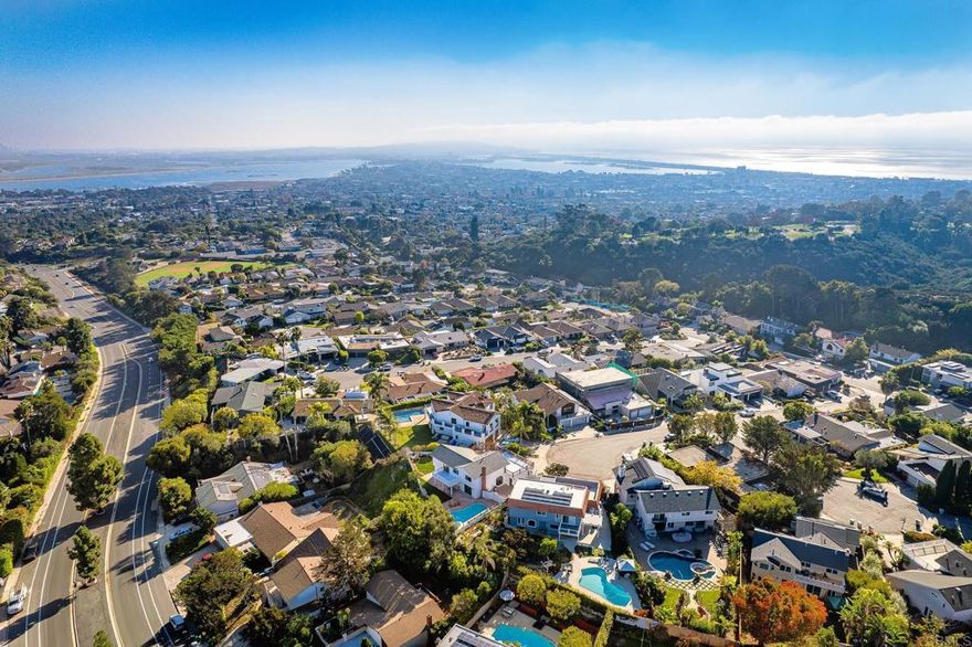 Tucked away on a cul-de-sac in one of Pacific Beach’s most sought-after hillside enclaves, this beautifully remodeled coastal residence captures scenic bay and ocean views with hillside outlooks from the primary bathroom and upper deck.  Thoughtfully redesigned with a balance of modern sophistication and timeless coastal style, the home offers refined finishes, curated details, and seamless indoor–outdoor living throughout. Custom millwork, shiplap accents, and bespoke cabinetry highlight the home’s elevated level of craftsmanship.  The light-filled main living spaces feature wide-plank hardwood floors, a dry bar, and an open, flowing layout ideal for both relaxed daily living and elevated entertaining. The chef’s kitchen serves as a striking centerpiece, featuring custom white oak cabinetry, wood accents, designer tile, Thor appliances, and a generous island that opens effortlessly to the family room and outdoor living areas.  The primary suite is a serene retreat, highlighted by bay and ocean outlooks and a spa-inspired bathroom with dual vanities, custom cabinetry, elegant fixtures, and a frameless glass shower. Additional bedrooms are generously proportioned and thoughtfully designed to accommodate guests, a home office, or flexible living needs, with multiple bathrooms updated in a cohesive, elevated style. Two upper-level bedrooms open directly to an expansive private deck—an exceptional setting for entertaining, relaxing, and enjoying coastal breezes, sunshine, and bay and hillside views. Designed for year-round enjoyment, the backyard offers a private, resort-style setting with a heated pool and spa, classic brick patios, manicured lawn, and multiple seating areas. Covered and open-air spaces extend the living experience outdoors, providing both privacy and versatility. Ideally located near Kate Sessions Park, the bay, beaches, dining, and shopping, this exceptional Pacific Beach residence delivers a rare combination of space, views, and refined coastal living.