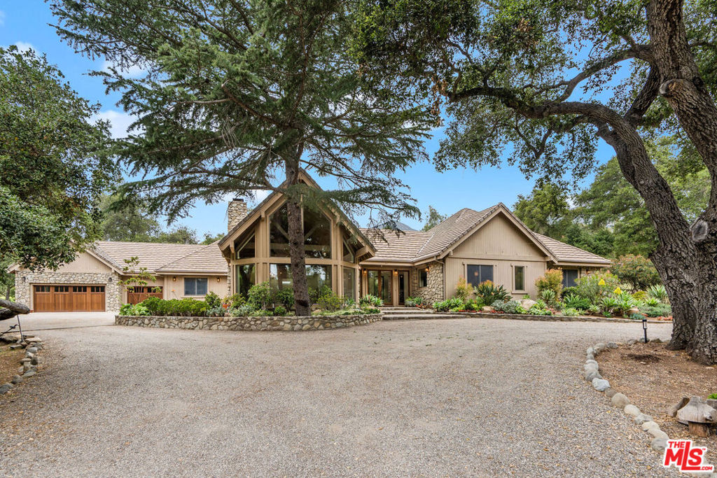 Located in Ojai's prestigious Arbolada/Foothill community on the highly desirable and private Palomar Road, this stunning Ojai estate offers the perfect blend of luxury, nature, and privacy set on nearly 5 acres of beautifully landscaped grounds just minutes from the heart of downtown Ojai. Surrounded by mature trees and sweeping greenery, the property feels like a secluded sanctuary, while still offering easy access to the town's renowned shops, restaurants, and vibrant arts scene. Recently remodeled, the home exudes a chic mountain lodge aesthetic, where natural textures meet modern elegance. The formal entry opens to a sunlit interior wrapped in windows, welcoming the outdoors into every corner of the home. At its heart, a grand chef's kitchen awaits featuring top-of-the-line appliances, an expansive island, and a full wine fridge, making it the perfect space for entertaining or everyday culinary experiences. The home offers thoughtfully designed living throughout, including a spacious laundry room and a dedicated office with custom built-ins ideal for remote work or creative pursuits. The finished garage includes generous storage and direct interior access, adding convenience and functionality without compromising on style. The breathtaking primary suite invites you to unwind with its cozy fireplace, spa-like bathroom, and a generous walk-in closet. Every room in the home is graced with oversized windows that capture the natural beauty surrounding the property, creating a seamless indoor-outdoor connection. An elegant circular driveway and grand front entry set the tone from the moment you arrive, while the sprawling grounds offer endless potential to create your own private compound. Add a pool, Fruit and vegetable garden, outdoor kitchen, or simply enjoy the tranquility of open space. To further elevate the possibilities, the property comes with approved plans and permits for a 1,400 sq. ft. guesthouse/ADU, ideal for extended family, or a private studio, media room etc... This is more than a home it's a rare and remarkable retreat where refined living meets the soul-soothing beauty of Ojai.