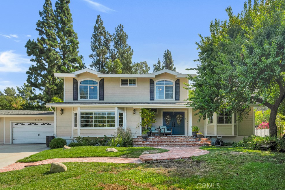 Located in sought-after Granada Hills, this exceptional property offers a stunning 4 bed, 2.5 bath main home plus versatile studio-style ADU on expansive 33,919 sq ft lot, providing endless possibilities for customization, multigenerational living, or additional income potential. A long, circular driveway leads to a 5-car garage, RV/boat parking, and access to the backyard. Great curb appeal with raised bordering planters, a grassy lawn, serpentine brick walkway, covered front porch, and double front doors with leaded glass. Inside, the formal entry opens to a flowing floorplan enhanced by hardwood floors, recessed lighting, and high-end finishes throughout. Versatile front room could be a 4th bedroom, cozy den, or office space. An impressive step-down living room boasts a beautiful, coffered ceiling, abundant natural light, a statement fireplace, contemporary French doors, and built-in storage. Adjacent stately formal dining room connects to the bright, sunny kitchen. Updated kitchen truly is a chef’s playground with granite counters, central island with prep sink, breakfast bar, and high-end, stainless-steel appliances including Viking range and flows seamlessly into an inviting, step-down, family room with bay window and deep window seat overlooking the yard. Upstairs, the generous, primary suite offers a coved ceiling, walk-in closet, French doors to a private balcony, and an en-suite bath with extra-large shower, dual vanities with granite counters. Down the skylit hallway are two additional bedrooms, both with crown molding, decorative chair rail large windows, and mirrored closets, a full hall bath with dual sinks vanity, and a convenient upstairs laundry room. The remarkable backyard features a sparkling pool and spa with natural stone coping, wide lawn edged with mature landscaping, basketball hoop, and large patio, partially covered, perfect for outdoor gatherings. The extensive hillside is covered with mature trees, including fruit trees. The property has a 5-car garage attached with direct access. The detached ADU includes its own brick porch, great room living space with wood floors and recessed lighting, kitchenette with cooktop, and a ¾ bath, making it ideal for extended family or rental income. Wonderfully situated near highly rated schools, shopping, dining, entertainment, recreation, parks and hiking trails, and major transportation thoroughfares. Don’t let this opportunity pass you by!