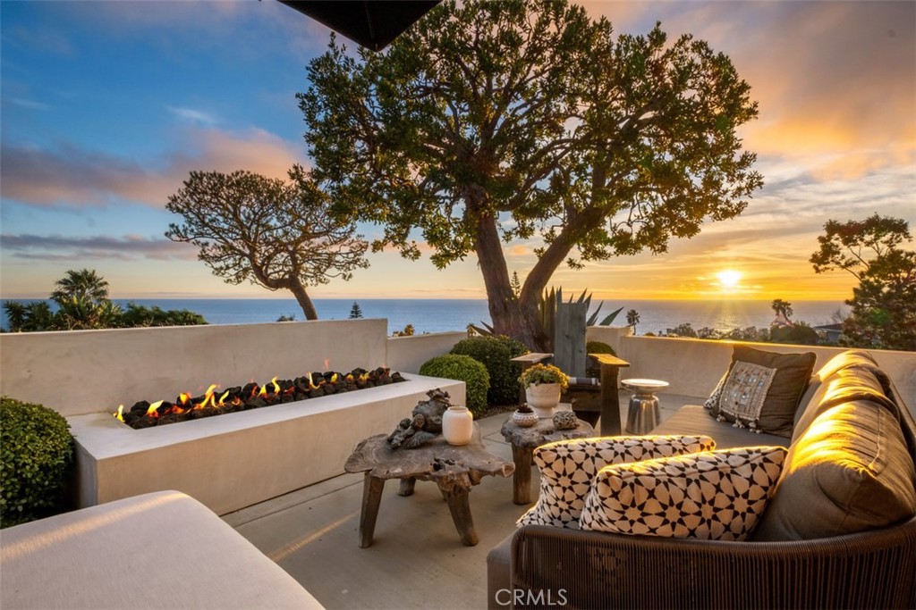 Coastal masterpiece, single-level, professionally designed home overlooking the Pacific. Impeccable landscaping leads to the private front patio with built-in fireplace and sweeping coastline and sunsets views. Fleetwood front doors lead to a grand open floor plan with clean lines, Exquisite Surfaces oak wood flooring and great room with expansive ocean views. The gourmet chef's kitchen includes a Wolf range, Sub-Zero refrigerator, built-in wine cooler, custom cabinetry and a grand Carrara marble island with ample counter seating and additional storage. Fleetwood sliding doors and windows, as well as custom cabinetry and built-ins, throughout home. The kitchen servery window opens to outdoor counter seating with direct access to the private side courtyard for seamless indoor-outdoor living. The picturesque courtyard creates a beautiful entertaining space complete with built-in Heston BBQ and Mexican Mangrove root sculpture, and is set against a European inspired hillside with mature olive trees. In the private rear yard is a heated spool and in-ground gas fire pit surround, adjoined by beautifully terraced landscape and outdoor shower. Mature citrus trees adorn the meticulous property along with a raised chef’s garden. Gracious primary suite with sliding Fleetwood doors open to the spool. Hotel inspired primary bath with Victoria and Albert soaking tub, walk-in shower, Kalista and Kohler faucets, Moroccan limestone and Zelige glazed tile. Walk-in closet complete with custom built-ins. Secondary bedroom with reclaimed wood wall detail and sliding door leads to the rear yard. Separate laundry room with custom built-ins and ample storage. House filtration system with RO cold and instant hot kitchen faucet. Studio/Casita creative use space with sliding doors that open to the courtyard. Dimmable LED lighting by Lightolier and sound system throughout. This impressively designed home, grounds and breathtaking ocean views provide for an unmatched lifestyle that must be seen to be truly appreciated.