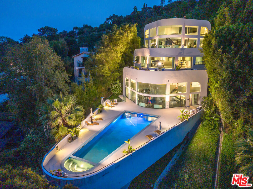 The 'Bel Air Yacht Mansion." Designed by world-renowned architect Glen Small. The private gated architectural, 26-room landmark was built on over 1/2 acre of land w/ incredible 300-degree jetliner views; perched perfectly on the Mulholland Corridor. This is the ideal entertainer's home! Along with 5 beds/8 baths, this property boasts a theater, gym, office, wine/cigar room, clubroom, a billiards lounge, (2) kitchens (main and club level), formal living room, family room, and dining area that all lead to a service counter/wet bar. All bedrooms are ensuite. Primary bedroom has 2 separate bathrooms both with roman baths for relaxation & escape, huge walk-in closets & private balcony area. There is about 2,500 sq ft of outdoor lounging decks w/2 separate hot tubs. Club level has an incredible 46 ft. color-changing lap pool w/spa, full kitchen, huge gathering area, and (2) separate baths. Other features include: eight-car private motor court, elevator and total privacy. Former residence to several A-List celebrities and has been the backdrop in many film, video, & TV productions. Plus, it has also hosted Oscar & Grammy afterparties and has recently collected $500K for a 6 month rental. This modern masterpiece is searching for its next lucky owner to take it to the next level. Incredible value/sqft!! The property was appraised at $13.5M. Appraisal report avail. upon request.