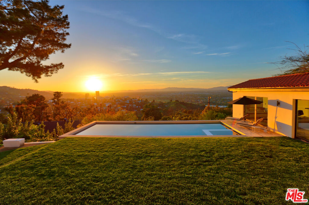 Perched atop Lake Hollywood with expansive views this prestigious estate property delivers on every level. Nestled among mature pine trees on a sprawling grassy flat lot this dream house is bathed in natural light & has been meticulously remodeled. Enjoy complete privacy & spa level finishes throughout in this stunning hideaway with 3 ensuite bedrooms in the main house plus a guest house (with Murphy Bed) and just over 5,000 sq. ft. of living space. Gourmet kitchen, formal dining & living rooms, library/study/den, media room with 85" screen/surround sound, bar with walnut finishes, multi-zone HVAC, Lifesource Water System, hardwood floors, gym, walk in temp controlled wine cellar and multiple patios and balconies with views in every direction from the Downtown LA skyline to the Western horizon. 40 ft pool & spa with Baja shelf and motorized cover, landscaped grounds with irrigation, lighting, fountains and custom outdoor BBQ and dining area. 2 car garage, 2 car carport, guest parking.