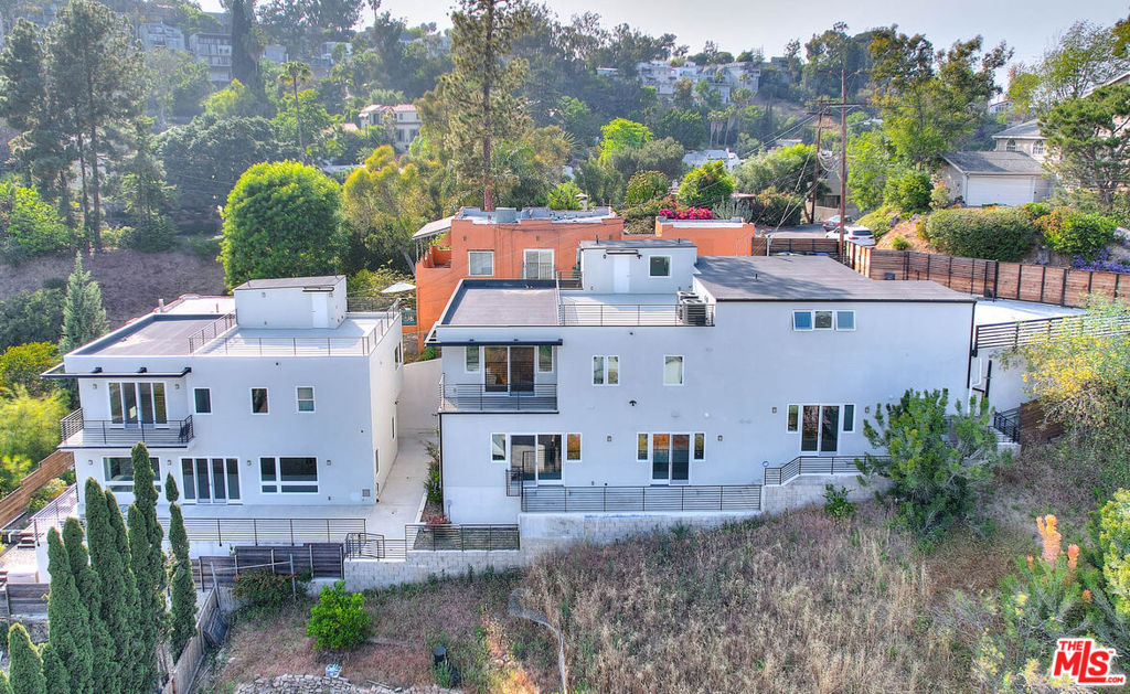 Welcome to 2610 Corralitas Dr - a rare opportunity to lease a spacious, modern home in one of LA's most vibrant neighborhoods. Perched in the hills of Silver Lake with sweeping views, this expansive residence offers over 3,900 square feet of thoughtfully designed living space that seamlessly blends comfort, privacy, and style. Enter through a fully automated gate into your private garage with direct access to the home. The open-concept layout greets you with oversized living areas, high ceilings, and refined finishes throughout. Large-scale tile flooring and warm hardwoods contrast beautifully with clean, modern lines, while the double-paned windows fill the home with natural light. At the heart of the home is a chef's kitchen featuring a massive island, sleek stone countertops, stainless steel appliances, and abundant cabinetry that is perfect for everyday living or hosting guests. The space flows effortlessly into the dining and living areas, which open out to a front patio ideal for morning coffee or enjoying the sunset. Upstairs, a massive bonus room offers incredible flexibility that is ideal as a gaming den, creative studio, home office, or gym. Each of the three spacious bedrooms is a private suite, complete with large walk-in closets and ensuite bathrooms outfitted with spa-inspired details. The primary bedroom also includes a private balcony with tranquil hillside views. Above it all, a private rooftop deck delivers panoramic views and the perfect setting for intimate gatherings. Additional highlights include a dedicated laundry room with built-in cabinetry, drought-tolerant landscaping, keyless entry, and central A/C. Located just minutes from Sunset Blvd, you'll be immersed in everything Silver Lake has to offer: artisanal coffee shops, trendy boutiques, music venues, and some of LA's most iconic eateries and culture. Experience Silver Lake living with space to create, entertain, and unwind.