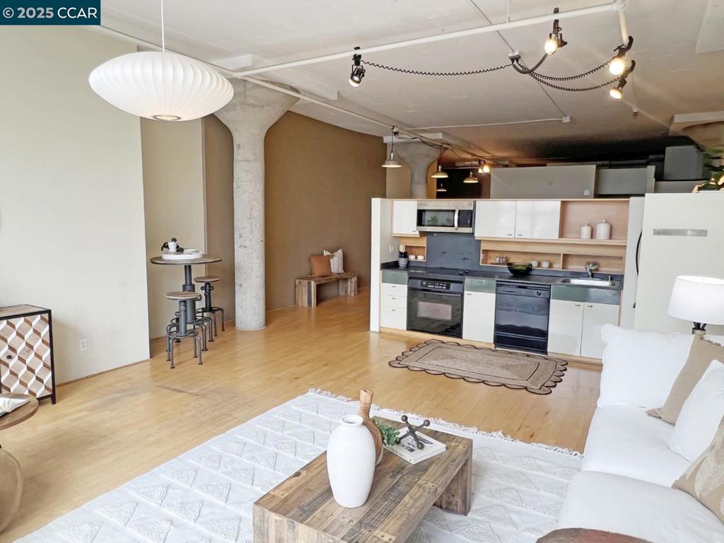 Discover modern urban living at its best in this bright and spacious 1-bedroom, 1-bathroom loft condo. Soaring ceilings, oversized windows, and an open-concept floor plan, this home is filled with natural light and contemporary charm. The sleek kitchen with ample cabinet space blends into the living area. The lofted bedroom creates a private feel while connecting to a large walk-in closet, the in-unit washer/dryer, and a spacious bathroom. Roof deck with 360-degree view, delivery package system, and enclosed garage with assigned parking, all while located near Huchin Park, shopping, and Emeryville Amtrak, make this a gem.