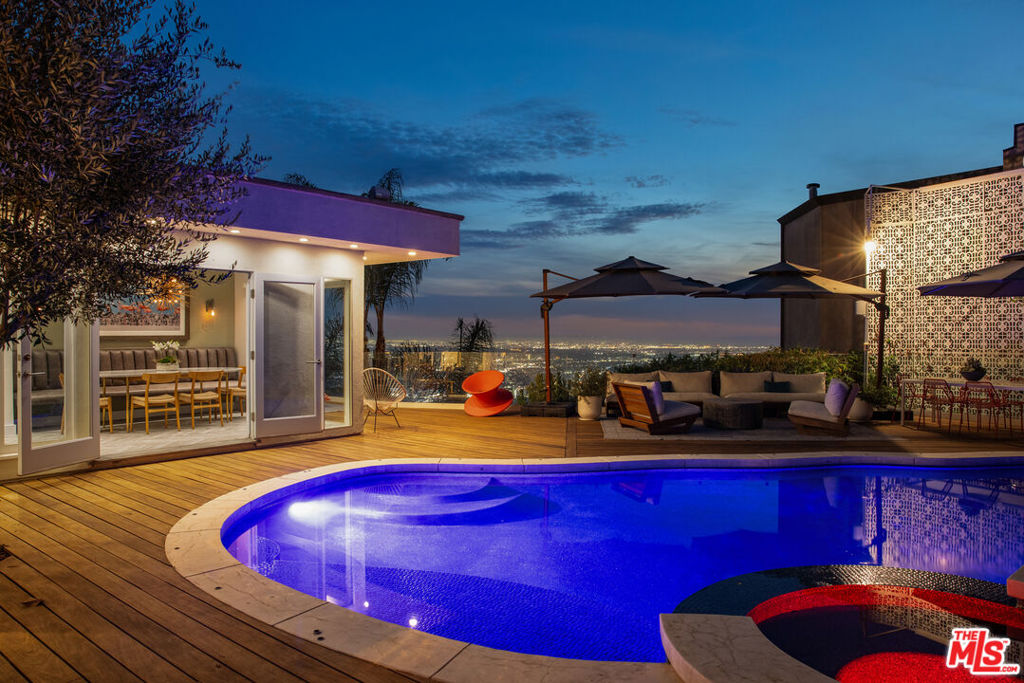 Beyond the walled and gated entry this one-story home offers breathtaking city and ocean views. Recently updated, it features a chic, high-quality design that enhances the open floor plan, high ceilings and sunlight spaces. The gated courtyard entry includes a tranquil koi pond. The gourmet kitchen boasts black marble countertops, gold fixtures, Ann Sachs tile backsplash, high-end stainless steel appliances and custom cabinetry. The primary bedroom suite is completed by a walk-in closet and an en-suite bathroom with dual sinks and a steam shower. French doors from the living room and both bedroom suites lead to a wraparound deck with a pool, hot tub, BBQ and a projection screen for outdoor movies. Conveniently close to world class shopping and entertainment.
