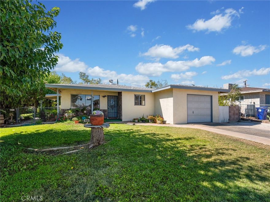 WELCOME HOME!!  Charming 3 bedroom/ 2 bath 1220 sq ft home nestled on a lovely corner lot, surrounded by lush green landscaping the adds warmth and curb appeal.  This adorable residence offers a cozy, yet open feel, perfect for comfortable everyday living.  Large living room area with sliding glass door leading to the delightful back yard with a covered patio.  The manicured lawn, vibrant plants, and mature trees create a peaceful outdoor retreat.  Attached one car garage includes laundry hook-ups.  Conveniently located in the heart of Victorville near, schools, shopping, 1-15 Fwy.   This property presents a great opportunity for first-time buyers, or investors, or anyone searching for a great little home!