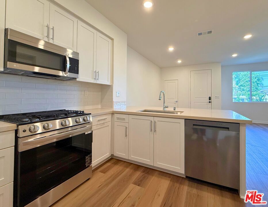 This move-in ready 3-bedroom, 2.5-bath townhome at The Grove at Merced in West Covina blends thoughtful design with everyday comfort. Plus, there is no Mello-Roos. A generously sized front patio greets you with full landscaped and hardscaped patio that brings a finished, refined feel to the exterior. It is an ideal space to enjoy a morning coffee, unwind after work, or entertain on weekends. Step inside to a bright, open-concept main level where LVP flooring flows throughout, adding modern texture and warmth while tying together the living spaces with clean visual continuity. Large windows bring in natural light, giving the great room, dining area, and kitchen an airy, welcoming feel. The kitchen truly stands out with its white shaker-style cabinetry, quartz countertops, stainless steel sink, and ample room for modern appliances. A peninsula offers additional workspace and supports bar-style seating, creating a casual dining area or a central spot for gathering with guests. The layout is functional and connected, perfect for both daily living and entertaining. A conveniently located powder room completes the main level. Upstairs, the primary suite includes a spacious walk-in closet and a well-appointed en-suite bath with dual sinks and a walk-in shower. Two additional bedrooms share a full bathroom and offer flexibility for guests, family, or a home office. A large upstairs laundry room adds practicality and extra storage. Included features such as energy-efficient dual-pane windows, built-in Wi-Fi prewiring, a programmable thermostat, and a smart video doorbell support a connected lifestyle. The home also includes a 2-car garage with EV-ready pre-plumbing and solar panels available for lease or purchase to help manage future energy costs. Located in a thoughtfully planned community with picnic areas, BBQs, green space, bike racks, and a dog station, this home combines timeless finishes with low-maintenance living in a convenient West Covina location. Some photos and virtual tour are of the model home and used for representational purposes only.