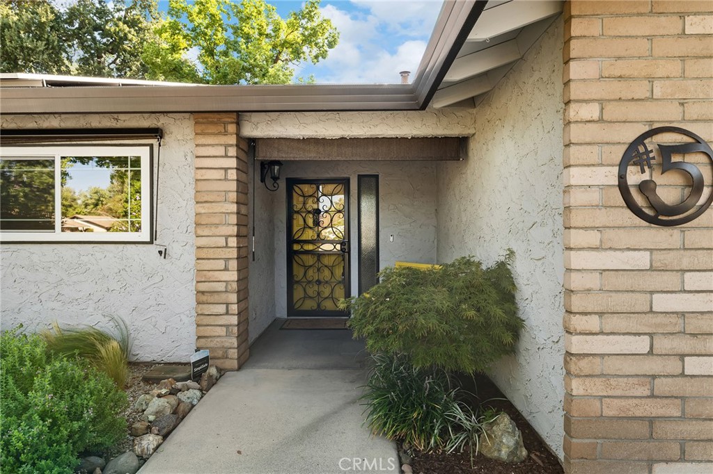 You’ll love 5 Greg Court—an updated, energy-smart home on a quiet cul-de-sac just blocks from Bidwell Park. Step inside to a large, light-filled living room dressed in beautiful window shutters—perfect for gatherings or a quiet morning coffee. The heart of the home is the bright, open kitchen with white shaker cabinetry, an oversized granite peninsula with seating, a chevron-pattern tile backsplash, stainless appliances, designer pendants, and a full wall of pantry storage. It opens to the cozy family room anchored by a classic brick fireplace with a gas insert and a big slider to the covered patio for easy indoor-outdoor living. Major improvements include new plumbing, a newer roof, owned solar, tankless water heater, dual-pane windows with exterior solar shades, and a whole-house fan. Both bathrooms are refreshed with new vanities and counters, plus there are new interior doors and closet doors, a new garage door, and new perimeter fencing. Stamped-concrete hardscape and low-maintenance front and back yards make weekends easy—just move in and enjoy. And the location seals it: close to Parkview Elementary, Marsh Junior High with quick access to Highways 32 & 99 for an easy commute; gas, pharmacy, shopping and restaurants are right nearby.