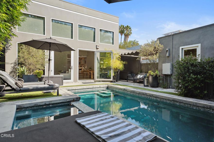 Behind sleek double gates, this architectural modern offers the ultimate in privacy, style, and comfort. Designed with clean lines and high-end finishes throughout, this residence blends form and function in every detail.The entire home is wrapped in Fleetwood windows and doors, flooding interiors with natural light while maintaining a sleek modern aesthetic. Inside, oak floors lead through a Bulthaup kitchen outfitted with Gaggenau appliances, including refrigerator, wine fridge, range with oven and steamer, plus a Miele dishwasher--a true showcase for those who appreciate culinary design. For convenience, a Miele washer and dryer complete the home's top-tier appliance package. Skylights and glass walls illuminate the open layout, connecting the kitchen, dining, and lounge areas.At the heart of the home, the dramatic Great Room features soaring 14-foot ceilings, polished concrete floors, and a contemporary fireplace. Walls of glass open to the heated saltwater pool and spa, creating seamless indoor-outdoor living.Two serene bedroom suites each offer Siberian marble baths, while thoughtful upgrades elevate everyday living--a whole-home water filtration system and air conditioning with integrated air purification.Outdoors, entertain in style with a galley kitchen complete with BBQ, sink, and prep space. A fully legal guesthouse (with certificate of occupancy) adds flexibility, offering its own grotto-style bath. Additional highlights include secured storage and a water cistern reclamation system. Close proximity to the best restaurants in LA and walking distance from CedarsSinai Medical Center, this is the prime location for luxury living.