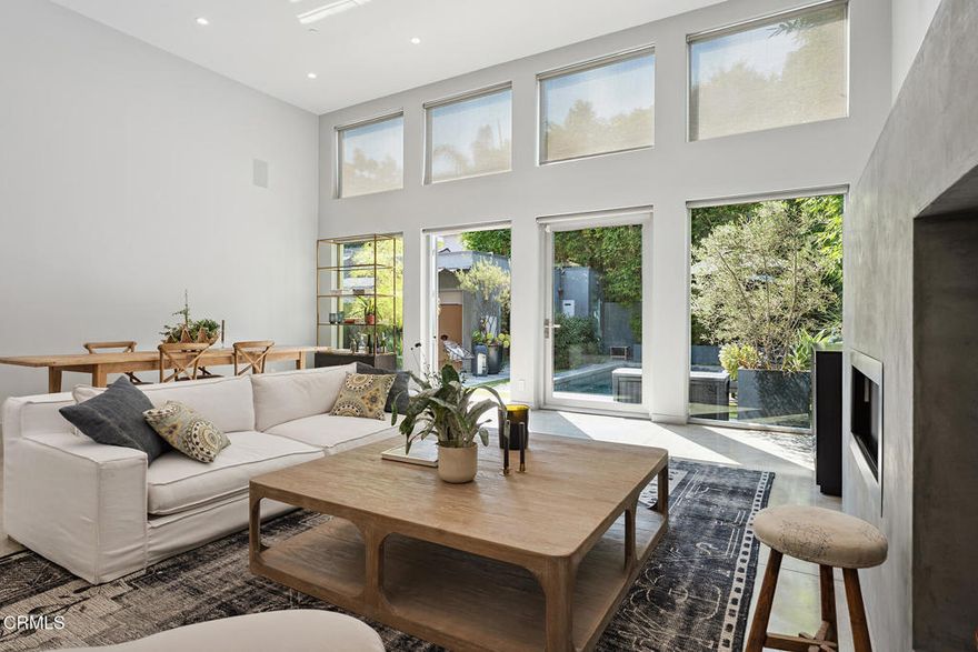 Behind sleek double gates, this architectural modern offers the ultimate in privacy, style, and comfort. Designed with clean lines and high-end finishes throughout, this residence blends form and function in every detail.The entire home is wrapped in Fleetwood windows and doors, flooding interiors with natural light while maintaining a sleek modern aesthetic. Inside, oak floors lead through a Bulthaup kitchen outfitted with Gaggenau appliances, including refrigerator, wine fridge, range with oven and steamer, plus a Miele dishwasher--a true showcase for those who appreciate culinary design. For convenience, a Miele washer and dryer complete the home's top-tier appliance package. Skylights and glass walls illuminate the open layout, connecting the kitchen, dining, and lounge areas.At the heart of the home, the dramatic Great Room features soaring 14-foot ceilings, polished concrete floors, and a contemporary fireplace. Walls of glass open to the heated saltwater pool and spa, creating seamless indoor-outdoor living.Two serene bedroom suites each offer Siberian marble baths, while thoughtful upgrades elevate everyday living--a whole-home water filtration system and air conditioning with integrated air purification.Outdoors, entertain in style with a galley kitchen complete with BBQ, sink, and prep space. A fully legal guesthouse (with certificate of occupancy) adds flexibility, offering its own grotto-style bath. Additional highlights include secured storage and a water cistern reclamation system. Close proximity to the best restaurants in LA and walking distance from CedarsSinai Medical Center, this is the prime location for luxury living.