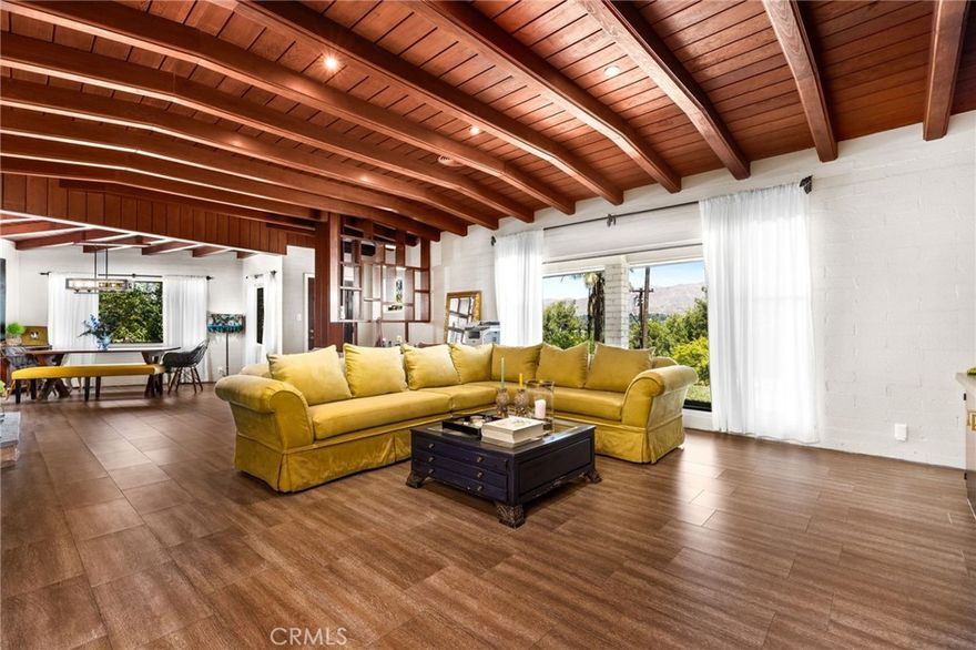 Welcome to 1872 Arroyo Drive — a one-of-a-kind mid-century gem perched in one of Riverside’s most sought-after neighborhoods, Victoria Woods down the street from the historic Victoria Country Club. This home is full of character, style, and warm architectural details you don’t see every day. Step out onto your front porch with a cup of coffee and take in breathtaking views that span the city. The views are truly one of a kind, consisting not just of Downtown Riverside, but also UCR and the surrounding mountains. Not many neighborhoods offer this view and very few homes in Victoria Woods have these incredible sunset views. Inside, you’ll find stunning wood beam ceilings, floor-to-ceiling windows, and timeless craftsmanship that make this home feel as special as it looks. Thoughtfully designed with abundant storage throughout, this home also offers a rare opportunity to add a Junior ADU — without sacrificing any existing bedrooms or bathrooms. It’s a perfect setup for multi-generational living or generating passive rental income. Out back, enjoy your private yard with space to relax in the hot tub and unwind with a glass of wine under the stars, and drive your golf cart over to Victoria Country Club. Don’t miss your chance to own a true Riverside original. This home is even better in person — schedule your showing today!
