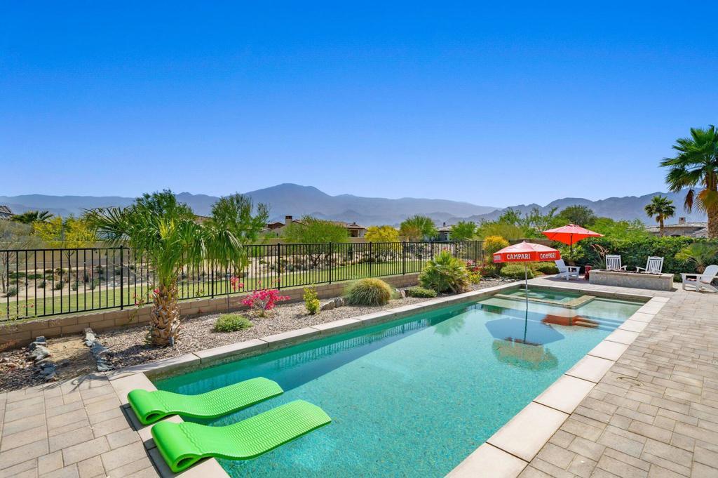Welcome home to this exquisite property located in Griffin Ranch, a prestigious, guard-gated luxury community in La Quinta. Designed with the discerning buyer in mind, this home offers unparalleled views and an exceptional indoor-outdoor living experience. Indulge in the breathtaking panoramic views that can be enjoyed from the great room, kitchen, dining room, primary bedroom, and the expansive patio. Whether you're hosting family gatherings or entertaining friends, these south-facing views are guaranteed to impress. Experience the epitome of indoor-outdoor living as the great room seamlessly opens to the extended covered patio. With walls of glass, misters, screens, and a cozy fireplace, you can enjoy the perfect blend of comfort and outdoor ambiance. The outdoor amenities are designed for enjoyment, from the built-in BBQ island for grilling to the saltwater pool and spa for relaxation. Spend your evenings around the fire pit, taking in the stunning sunsets. Step inside and be greeted by custom flooring, beautiful window treatments, a great room adorned with coffered ceilings, and a fireplace featuring stacked stone. The chef's kitchen is a culinary delight, boasting stainless appliances, a five-burner range, and exquisite countertops. Adjacent to the kitchen, you'll find a spacious dining room, entertainment areas, and a bonus room. There are also two bar areas, perfect for hosting social gatherings. Retreat to the primary suite with its high ceilings, en-suite bath offering dual vanity sinks, a spacious shower, and a deep soaking tub for ultimate relaxation. The walk-in closet is sure to impress. The guest rooms are thoughtfully designed and provide comfortable accommodations for visitors.This home features an attached Casita with a separate entrance for added convenience. The Casita includes a kitchenette, living room, bedroom, bath, and direct access to the golf cart garage. Griffin Ranch offers an array of amenities for residents to enjoy. The clubhouse is a luxurious retreat with a fitness room, pool and table tennis room, pilates studio, bocce courts, tennis courts, a putting green, and pickleball courts. There's even a doggie park for your furry friends. Relax by the resort-style pool & spa with cabanas, and partake in the numerous social activities held throughout the year. With its prime location, you'll have easy access to world-class golf courses, tennis facilities, shopping, dining, biking trails, theaters, & everything the desert offers.