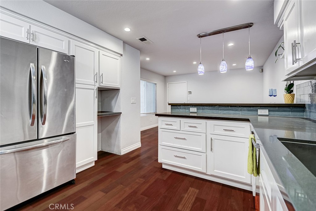 Turnkey remodeled 3-bedroom, 2.5-bath with Recessed lighting throughout, townhome in a desirable gated Gardena community. The home features a bright, welcoming layout with a spacious living and family area downstairs, complete with beautiful flooring and a cozy gas fireplace. A skylight over the stairs fills the space with natural light, and high vaulted ceilings upstairs create an open, airy feel. Large sliding doors open to a private backyard, perfect for relaxing, entertaining, or picking lemons from your own tree. The interior location ensures peace and quiet, away from street noise.
The remodeled kitchen boasts modern white cabinetry, quartz countertops, and stainless-steel appliances, including a dishwasher. A convenient half bath is located on the main level, along with direct access to the attached two-car garage, which features built-in storage cabinets.
All bedrooms are located upstairs, with the laundry area nearby for convenience. The primary suite offers two walk-in closets with custom shelving and a beautifully remodeled bathroom with dual sinks, a tub/shower combo, and a separate vanity area. All bathrooms have been tastefully updated.
Additional highlights include air conditioning for hot days, an upgraded electrical panel, and a gated community with a sparkling pool. Nothing to do but move in!
