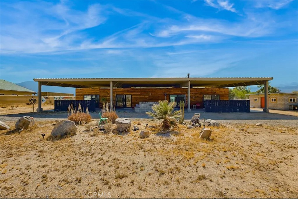 Discover the Elemental Retreat House, a modern home designed by a renowned San Francisco architect and nestled on a 1.25-acre secluded lot located just outside of Desert Hot Springs. This 2000 sq.ft., 3-bedroom, 2 bath home offers tranquility, eco-conscious design and income-generating potential, all just 20 minutes from downtown Palm Springs and a short drive to Coachella. Large double-pane sliding doors positioned, every 8 feet, frame breathtaking 360-degree mountain and desert views. The home is divided into two 1000 sq. ft. wings, connected by a covered central space with pull up door, creating a weather protected indoor/outdoor living area. The main wing houses a guest bedroom with bath, a spacious living room, dining area and fully equipped kitchen. The other wing houses two expansive 450 sq.ft. master suites, featuring 2 sliding doors each that open to spacious covered patios, perfect for morning coffee or stargazing under the desert sky. The innovative double-roof design, with a 5,000-square-foot top roof, shields the home from the desert sun while channeling cooling breezes between the roofs, ensuring comfort even in the hottest months. Wrapped in 18 inches of Styrofoam insulation and clad in elegant cedar, this super-insulated home achieves near-zero energy consumption, complemented by a one-year-old solar system that virtually eliminates electricity costs. The heart of the Elemental Retreat House is its therapeutic mineral water well, delivering odorless, 85°F mineral-rich water year-round. Packed with health-enhancing minerals, this water fills the oversized pool, luxurious jacuzzi, and all showers, transforming your home into a private spa retreat. Additional amenities include a large laundry/storage room with a sink and new water heater, mini split air conditioners for personalized comfort, and smart home features controlling the pool, spa, lighting, and security system via Wi-Fi. Guests on a recognized short term rental site have awarded this property a 5-star rating, praising its wellness-focused amenities and serene ambiance, making it a proven income generator with an active short-term rental permit from Riverside County. Situated on the outskirts of Desert Hot Springs, known as California’s Spa City, this property combines seclusion with proximity to world-class attractions. Enjoy the vibrant arts, dining, and festivals of Palm Springs, or explore nearby Joshua Tree National Park and San Bernardino National Forest.