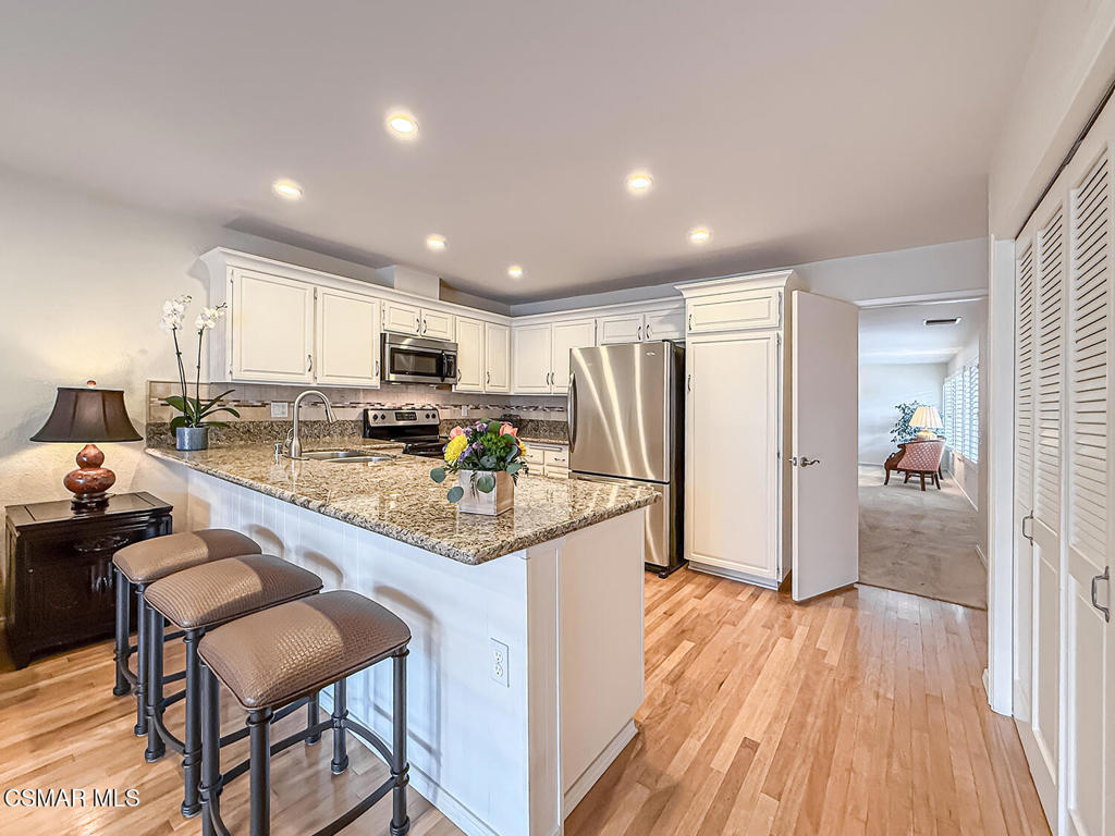 Charming Single-Story Retreat in the Heart of Westlake Village with NO Interior Steps, NO Rear Neighbor, CORNER Location, PRIVATE Front & Back Patios, UPGRADED Kitchen & Baths, and WALKABILITY to Westlake Lake! Tucked within the peaceful and well-maintained community of Triunfo West, this 2-bed / 2-bath home offers a bright floorplan with community features including TWO Pool & Spa areas! From the moment you enter the gated front patio--lined with lush greenery--you'll appreciate the sense of calm and comfort that defines this property. Step inside and you're welcomed by HANDSOME real wood flooring and an open-concept Living & Dining Room with plush carpet, a dual-sided fireplace, and THREE pairs of tall windows that overlook the patio, bathing the space in natural light. The upgraded Kitchen boasts attractive granite countertops, mosaic-tile backsplashes, a stainless-steel sink, and matching Frigidaire stainless-steel appliances--all complemented by ample cabinetry & pantry storage! A bright and inviting Family Room sits just off the Kitchen, enjoying large sliding glass doors that open to the backyard and frame serene green views. Tucked behind bifold doors, the indoor Laundry Area flanks the Kitchen to make laundry effortless & convenient! The spacious Primary Bedroom is a peaceful sanctuary with tall windows & sliding glass doors to the backyard, and TWO mirrored closets. Its en-suite bathroom features an upgraded stone-topped vanity with skylight above, plus a separate water room with fully revamped shower, artistic tilework, and frameless glass doors. The Secondary Bedroom offers excellent flexibility--perfect for guests or a home office--with wood flooring, a FANTASTIC Murphy bed, built-ins, and views of the front patio. The full Hall Bathroom has also been redone with upgraded tile floors, a built-in stone-surfaced vanity, and a redone tub/shower combo with tile surrounds + frameless glass doors! Step outside to your PRIVATE backyard retreat--with NO rear neighbor--only peace and greenery beyond! Enjoy the covered concrete patio and side pathway which showcases a VIBRANT row of blooming rose bushes in every shade--pink, red, yellow, orange, white and more! Your 2-car garage is directly accessible from the front patio and is complete with built-in cabinetry. Residents of this sought-after community enjoy access to TWO sparkling pools & spas, shuffleboard courts, greenbelts, and scenic walking paths--all just moments from Westlake Lake, boutique shopping, and fantastic restaurants.This is the kind of peaceful, bright, and thoughtfully updated home that rarely comes available in such a prime Westlake Village location--don't miss it!