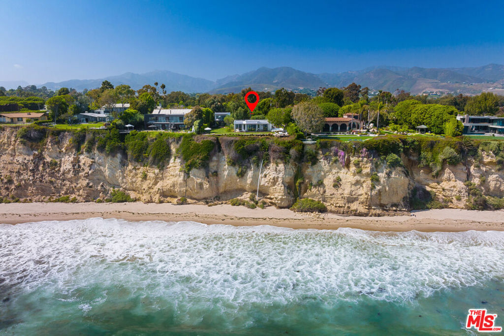 Home to world-class surfing, this reimagined modern villa provides seamless indoor-outdoor living with exotic patios amidst gardens, lawns, and ocean panoramas. Perched on a bluff above scenic Dume Cove with 110' frontage, are a single-story main house and two-story guesthouse on over an acre. Ten-foot plank and beam ceilings, generous windows, gorgeous distressed oak floors, and custom-designed teak furniture are combined in a relaxed, sophisticated open-concept design. The courtyard entry of the main house features a covered dining area, ocean-view great room, and bright kitchen with an eat-in island. A wall of glass opens onto an outdoor living room/covered patio and huge bluff-top lawn for recreation and entertaining. The owner's suite has a private patio with an outdoor living area. Completely separate, the guesthouse has a spacious covered patio, ground-floor bedroom, and upstairs living area with kitchen and glass accordion doors that open onto an ocean-view deck. The estate includes a new Airstream and Riviera 3 beach keys. Available for sale at $44,750,000.