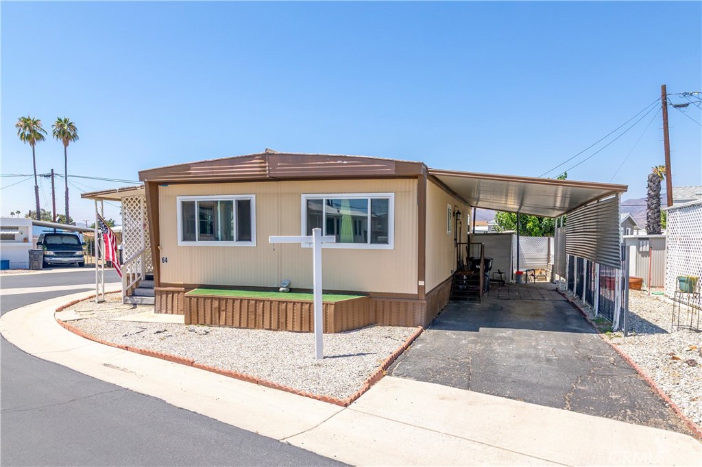 Welcome to this charming and budget-friendly 2-bedroom, 1-bathroom mobile home, ideally situated on a desirable corner lot in a peaceful 55+ community in Hemet. Offering approximately 800 square feet of well-designed living space, this home features a bright and open floor plan with updated laminate flooring throughout, adding a fresh and modern touch. Step inside to a light-filled living room that feels warm and welcoming—perfect for both quiet evenings and casual entertaining. The kitchen is functional and cozy, and the in-home washer and dryer hookups offer everyday convenience. One of the standout features of this property is the spacious covered front porch—ideal for enjoying your morning coffee, relaxing with a good book, or chatting with friendly neighbors. The corner lot location provides added privacy and curb appeal, with easy access and a little extra space to enjoy. Additional highlights include a covered carport with room for two vehicles and access to the community’s well-kept amenities, including a sparkling swimming pool and clubhouse. Whether you're downsizing or seeking an affordable and low-maintenance lifestyle, this move-in ready home checks all the boxes. Don't miss the opportunity to own this delightful corner-lot gem—schedule your private showing today!