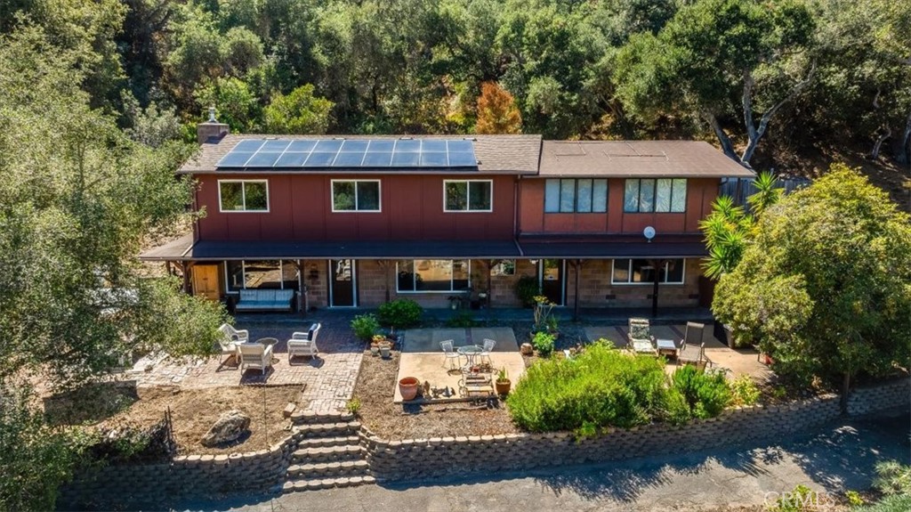 *Please no access to property or parcel without appointment.* Private retreat on over five peaceful acres just off Corbett Canyon Road on scenic Deer Canyon Road, this property offers a rare combination of privacy, income potential with guest units, creekside charm and natural beauty. Formerly home to thriving orchards, the land is now dotted with mature fruit trees and crowned by nature, creating a tranquil and secluded atmosphere ideal for classic country living. A private driveway leads you to the main residence, which has been updated and remodeled nearly throughout. Features include a fireplace, welcoming stairway, kitchen island, and generous upstairs area for recreation. The main home includes four bedrooms, two ¾ baths, and a separate 2-bedroom living space with its own entrance and bath—perfect for extended family, guests, or rental use. Uniquely, the upstairs level of main home can be easily accessed from an upper level of the driveway. In addition, there is a detached 1-bedroom guest unit (576 SF per County of SLO )offering even more flexibility for short- or long-term stays. Currently operating partially as a vacation rental, this property is ready for both full-time living and investment income. A charming footbridge over a seasonal creek adds storybook appeal to the grounds, and a shared well supports both the main and guest units. Additional highlights include a garage, 4 sheds, and the peace of a private road, ideal for those seeking a quiet, rural lifestyle just minutes from town. The solar system serving the property is 7.2kW. This is a one-of-a-kind opportunity to own a private compound in the heart of the Central Coast—whether you're looking to settle in, invest, or simply enjoy the peace of country living.