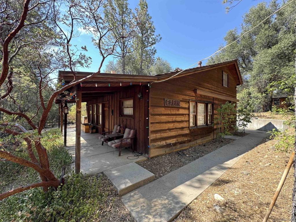 Nestled among mature oak and pine trees, this charming two-story cabin on a .52-acre parcel offers timeless mountain living. The centerpiece is a floor-to-ceiling rock fireplace in the living room, complemented by wood beam ceilings and walls that embrace cabin charm. A mini-split system ensures year-round comfort. The kitchen features knotty wood cabinetry, tiled counters, an antique range/oven, and refrigerator. With three bathrooms, a primary suite, and a loft bedroom designed to sleep 10, there’s space for everyone. Relax on the covered front porch, enjoying crisp air and birdsong, or gather around the fireplace after a day outdoors. Conveniently accessed off paved Rocky Pass Rd, this retreat is just minutes to town, I-8, and only 45 minutes to downtown San Diego.