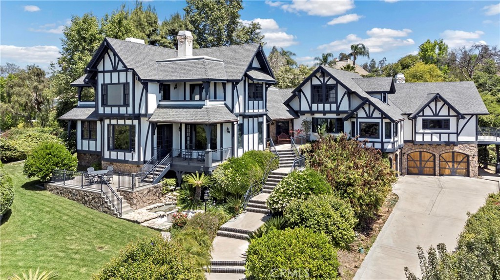 Welcome to 7008 Hawarden Dr, a magnificent Tudor-style estate nestled in Riverside’s prestigious Hawarden Hills neighborhood. This custom-built residence showcases exceptional craftsmanship and timeless elegance. Spanning approximately 6,364 square feet, the main house features five bedrooms, six bathrooms, and a wealth of luxurious amenities.
Upon entering, you're greeted by a grand two-story foyer leading to formal living and dining areas adorned with oak hardwood flooring, high ceilings, and balconies offering panoramic city, mountain, and sunset views. The gourmet kitchen boasts granite countertops, a butler's pantry, and a cozy breakfast nook. Entertainment spaces include a billiard room with a bar, a family room with a loft, and a temperature-controlled wine cellar with a tasting room. Additional spaces include two offices and a library, providing flexibility for work or relaxation.
The approximately 1.85-acre gated property offers tranquil walking paths, a sparkling pool and spa, a cabana, and a sun deck—ideal for entertaining or quiet retreat. A detached 1,100 sq ft guest house includes two bedrooms, a full bathroom, living room, workout room, kitchenette, and its own two-car garage. With a six-car garage, RV parking potential, and close proximity to top-rated schools, this exceptional estate exemplifies luxury living in Riverside.