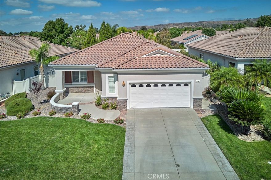 Pristine Trillion model in the gated 55+ community of Solera. The outdoor spaces are a true highlight—exquisitely landscaped front and back yards with palm trees, a putting green, and extended patios. The kitchen showcases granite countertops and ample cabinetry, flowing into a spacious living room with a cozy gas fireplace. A den/office includes a built-in desk and extra recessed lighting. Plantation shutters add a clean, finished touch. The primary suite offers a walk-in shower, soaking tub, and a generous walk-in closet. Plenty of extra storage cabinets in the garage. As a Solera resident, you’ll enjoy resort-style amenities including a clubhouse with library, banquet facilities, billiards, fitness center, pool, spa, bocce ball, and tennis courts. There are also many clubs to join and organized trips. Spectrum internet and basic cable are included. Solera offers easy access to Redlands, Cabazon Outlets, the best golf courses and short drive to Palm Springs. There's no place like your new home!